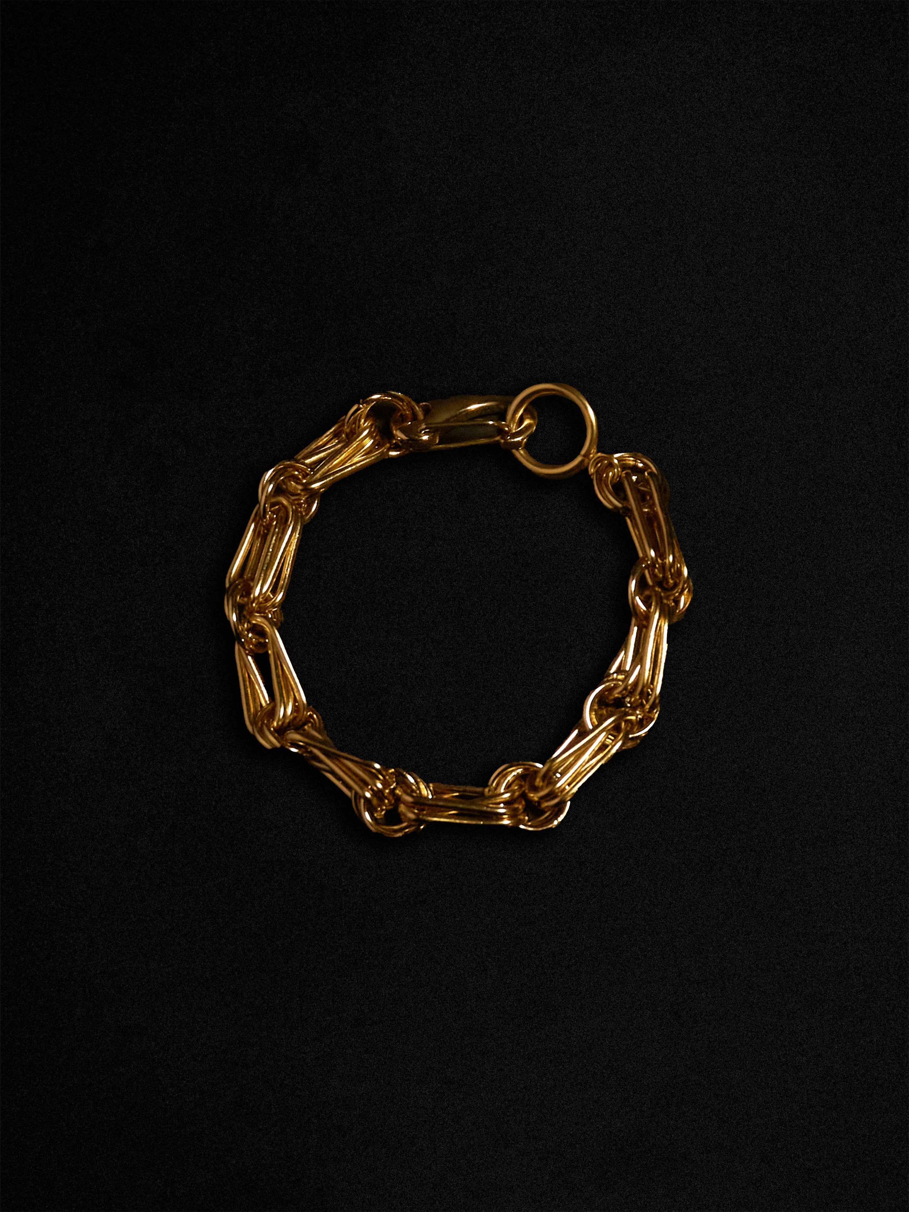 Gold chain bracelet on a black background