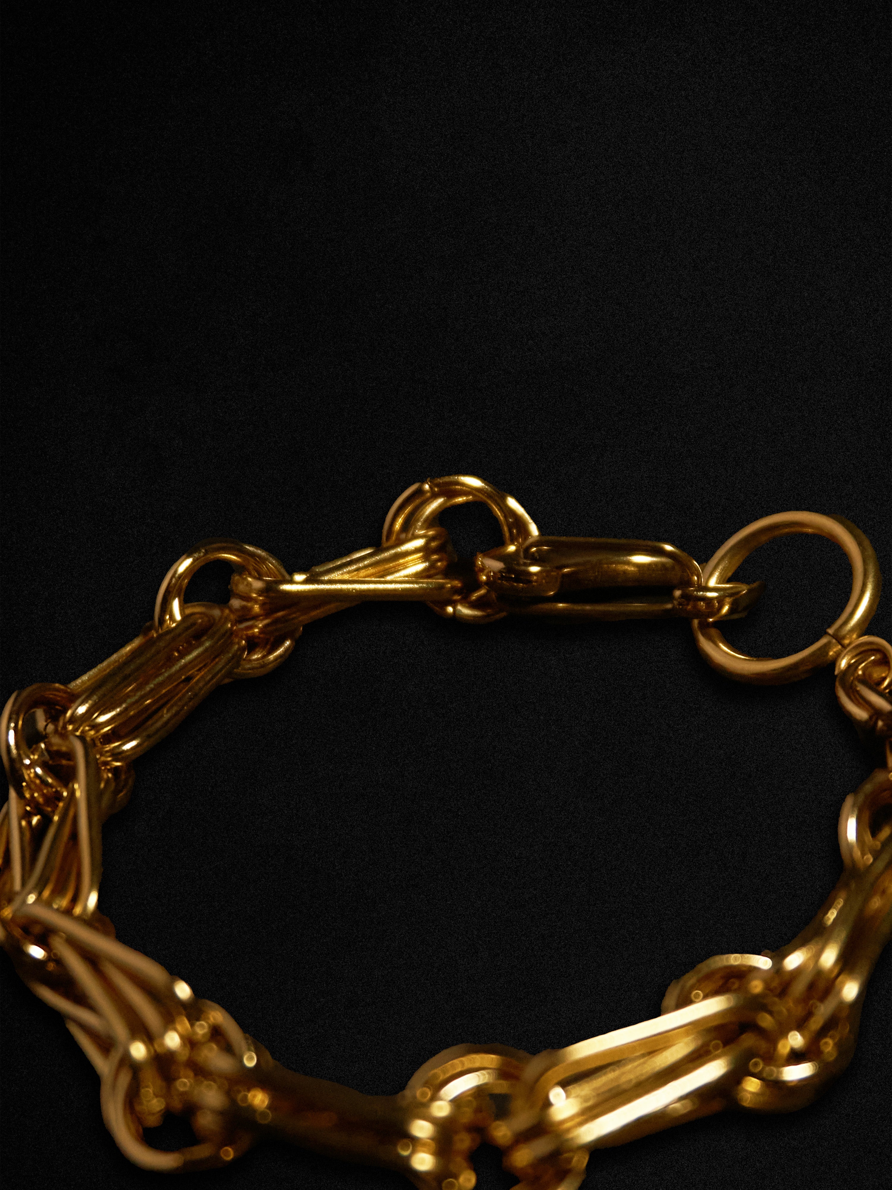 Gold chain bracelet on a black background