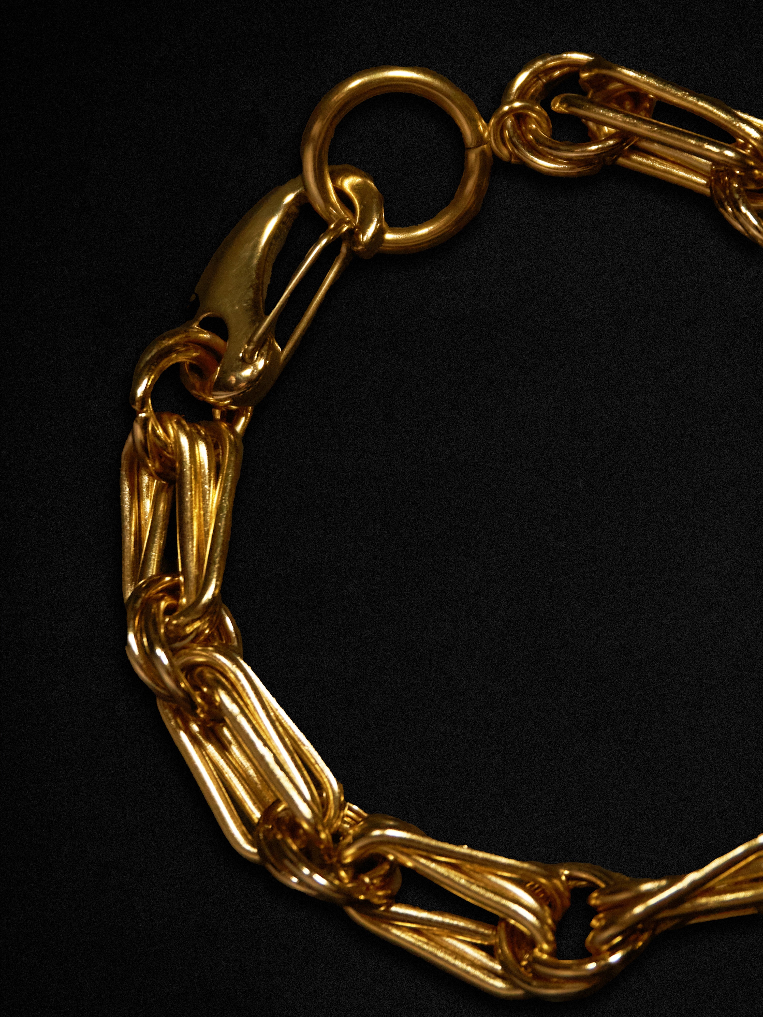 Gold chain bracelet on a black background