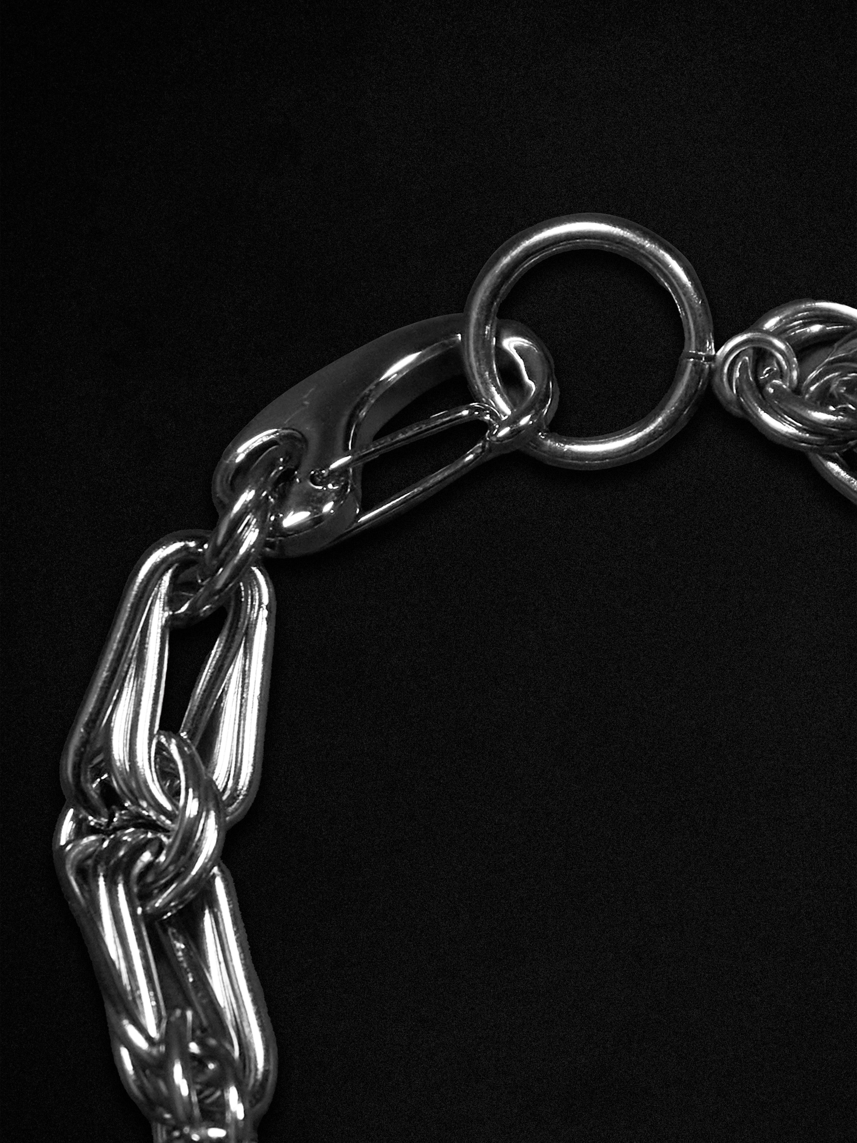 Close-up of a silver chain bracelet on a black background