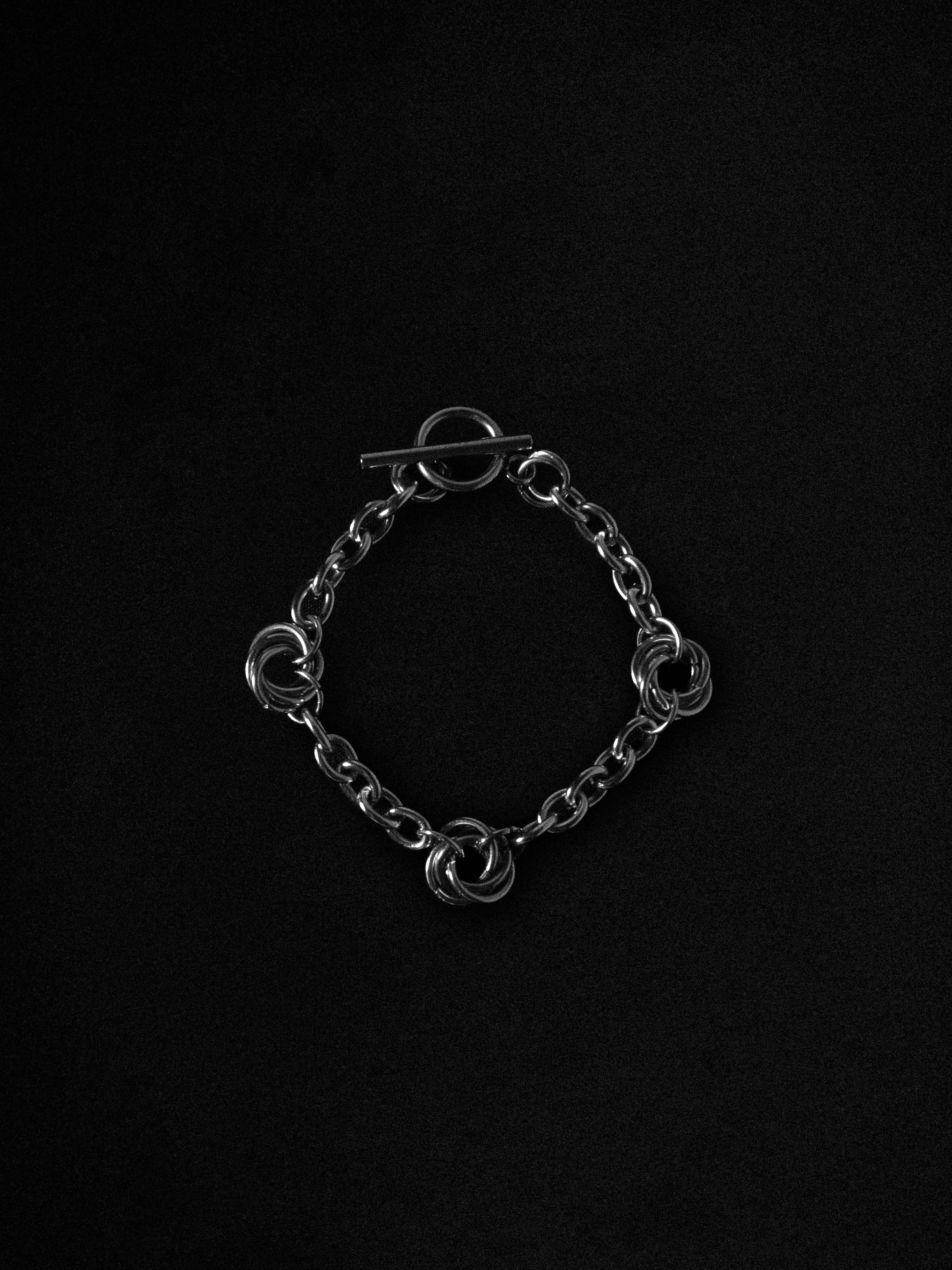 Silver chain bracelet on a black background