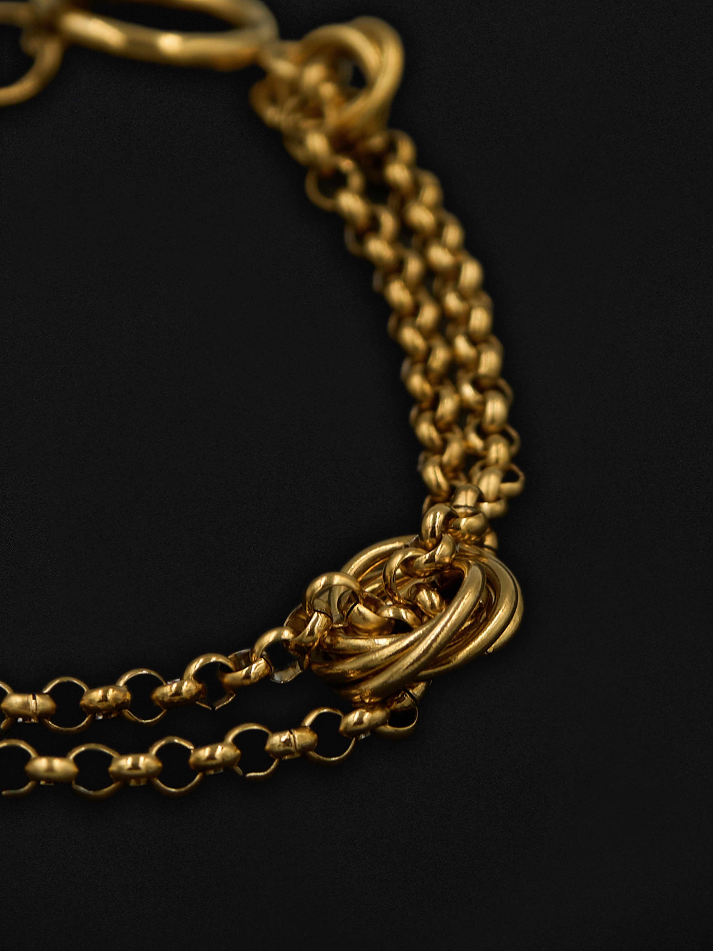 Close-up of a gold chain bracelet on a black background