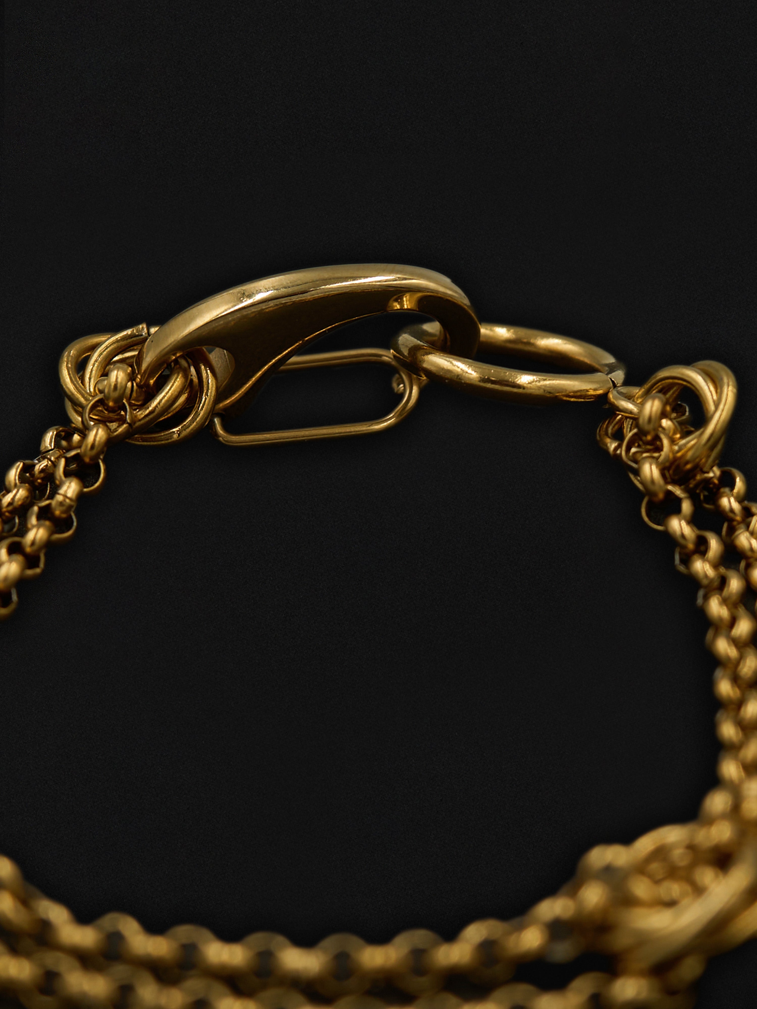 Gold chain bracelet on a black background