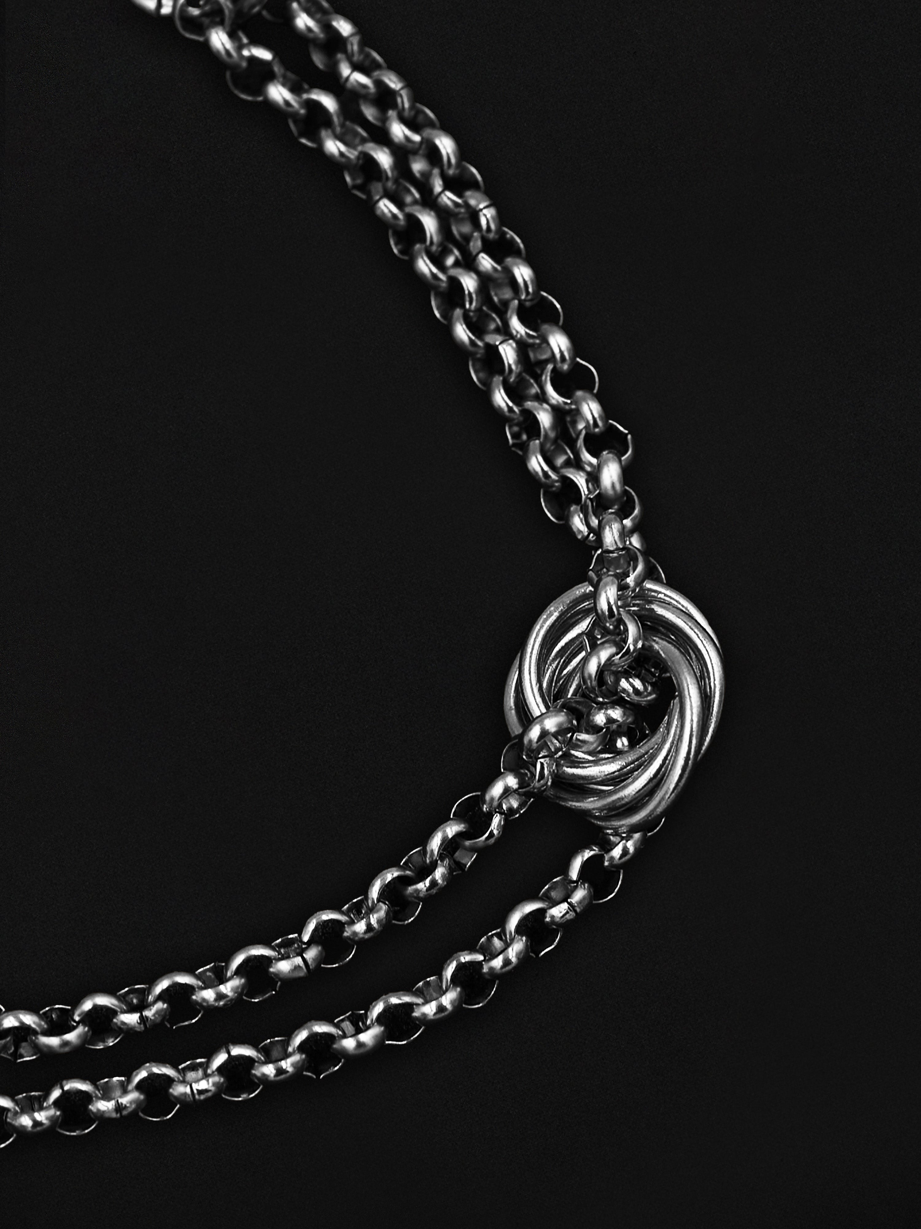 Silver chain with a knot design on a black background