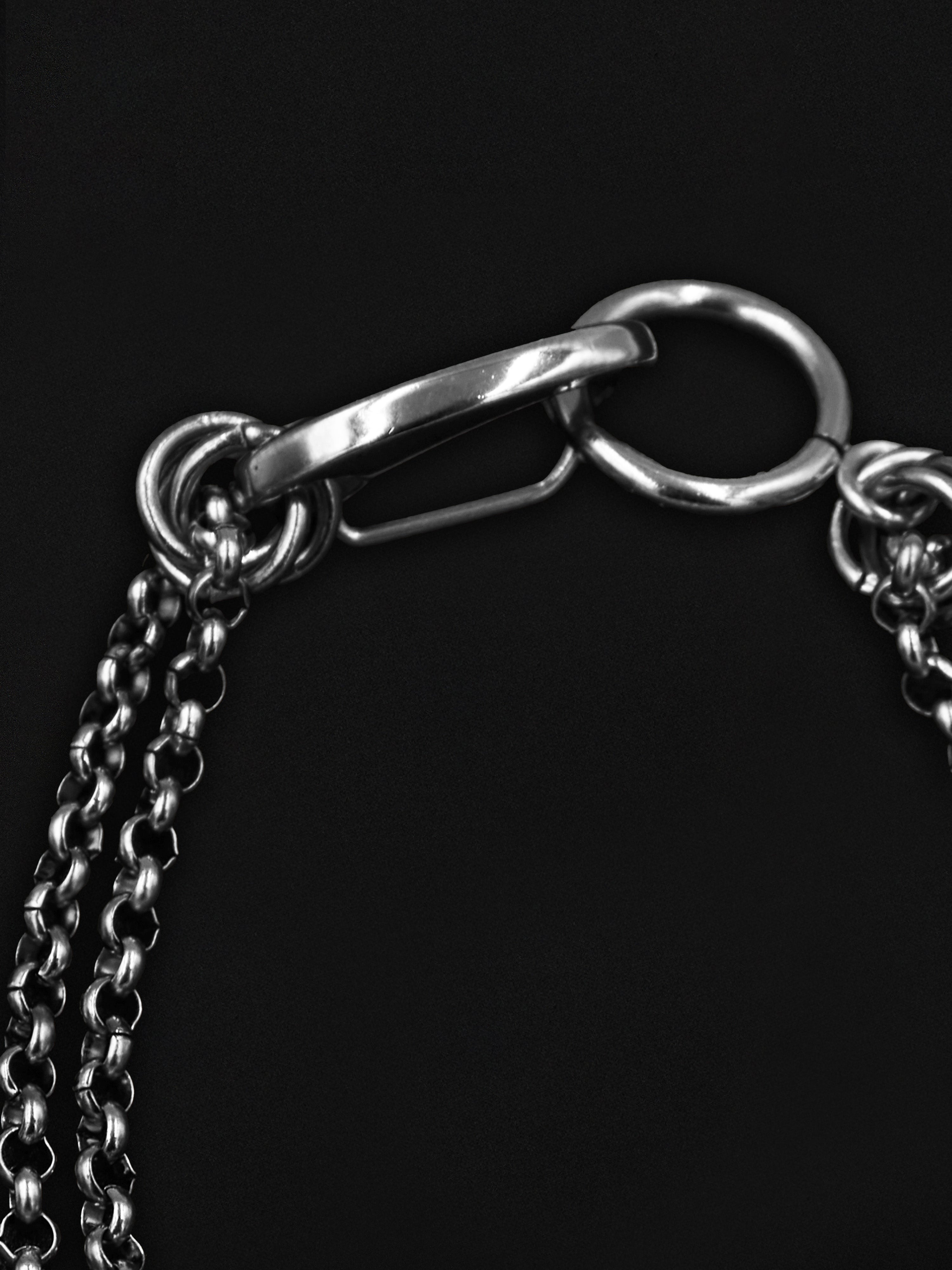Close-up of a silver chain with a clasp on a black background