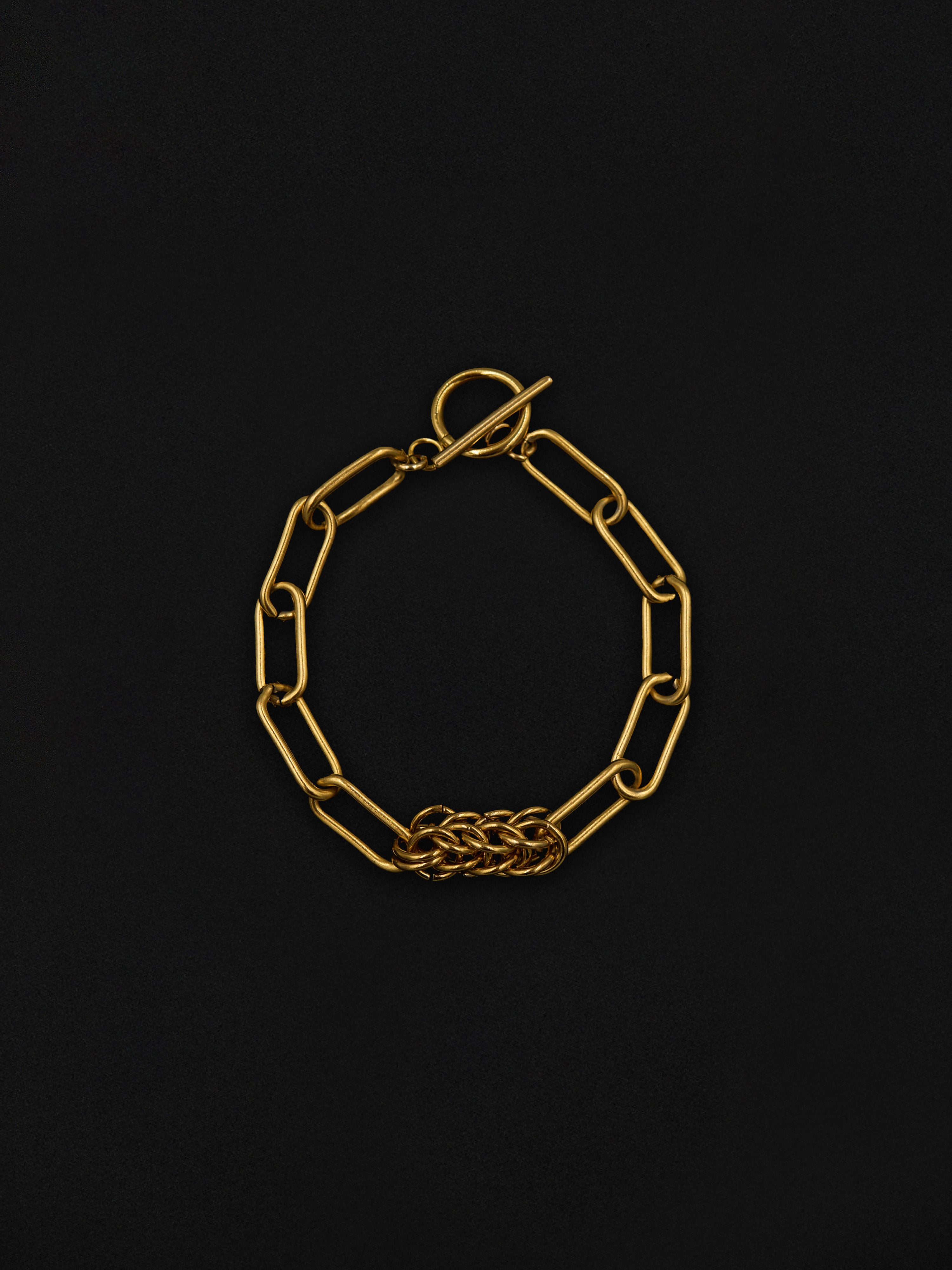 Gold chain bracelet on a black background