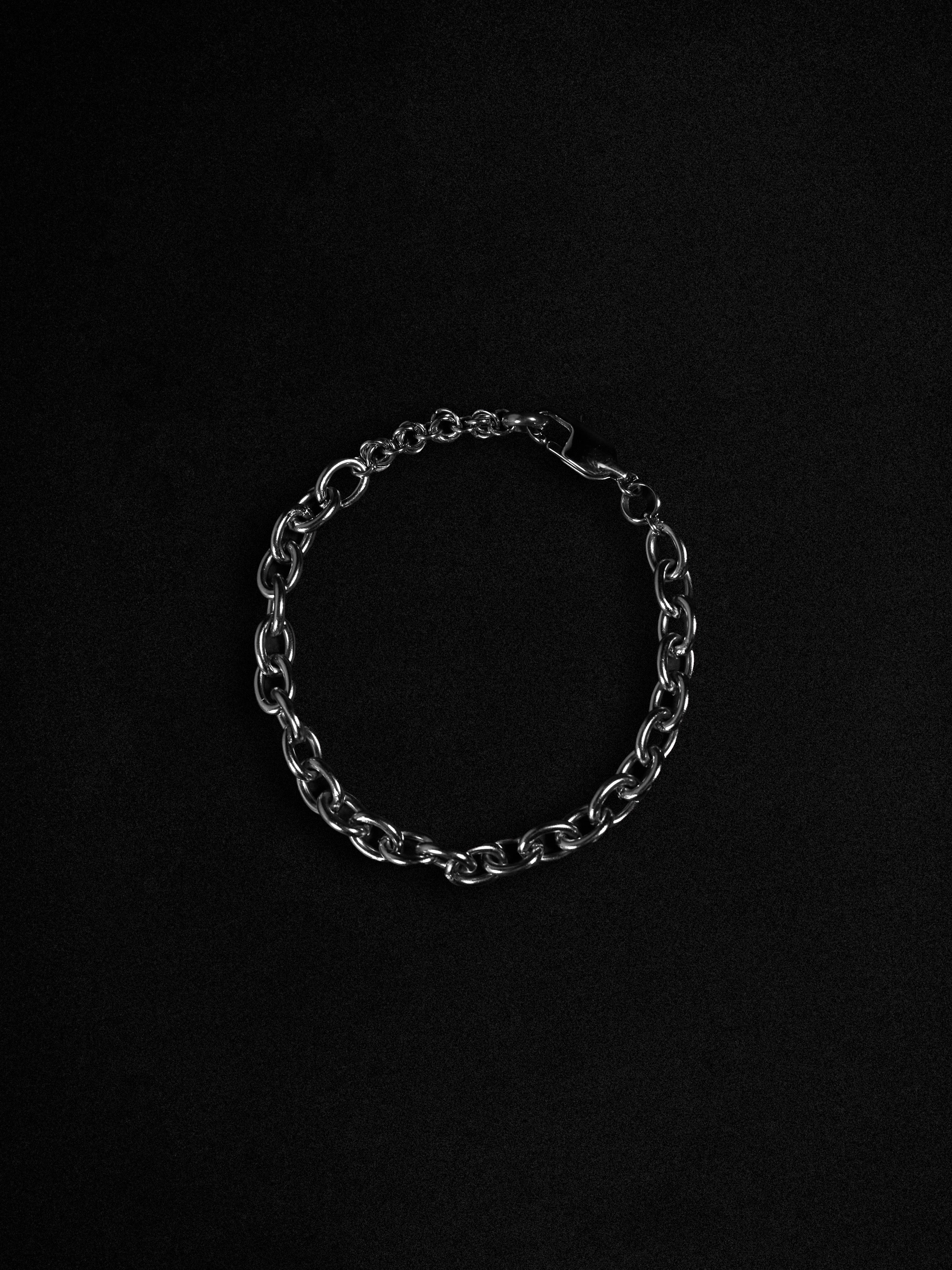 Silver chain bracelet on a black background