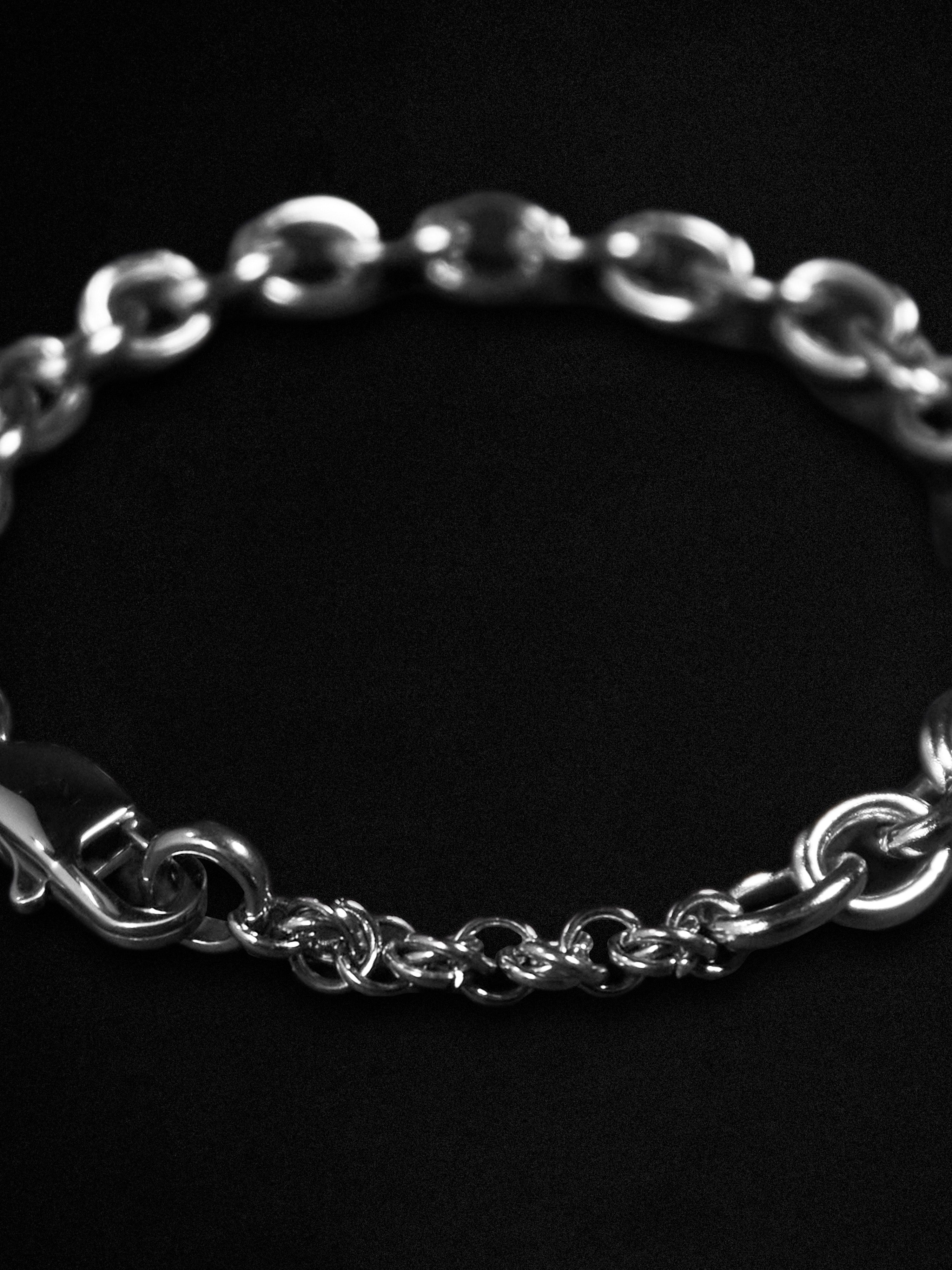 Silver chain bracelet on a black background