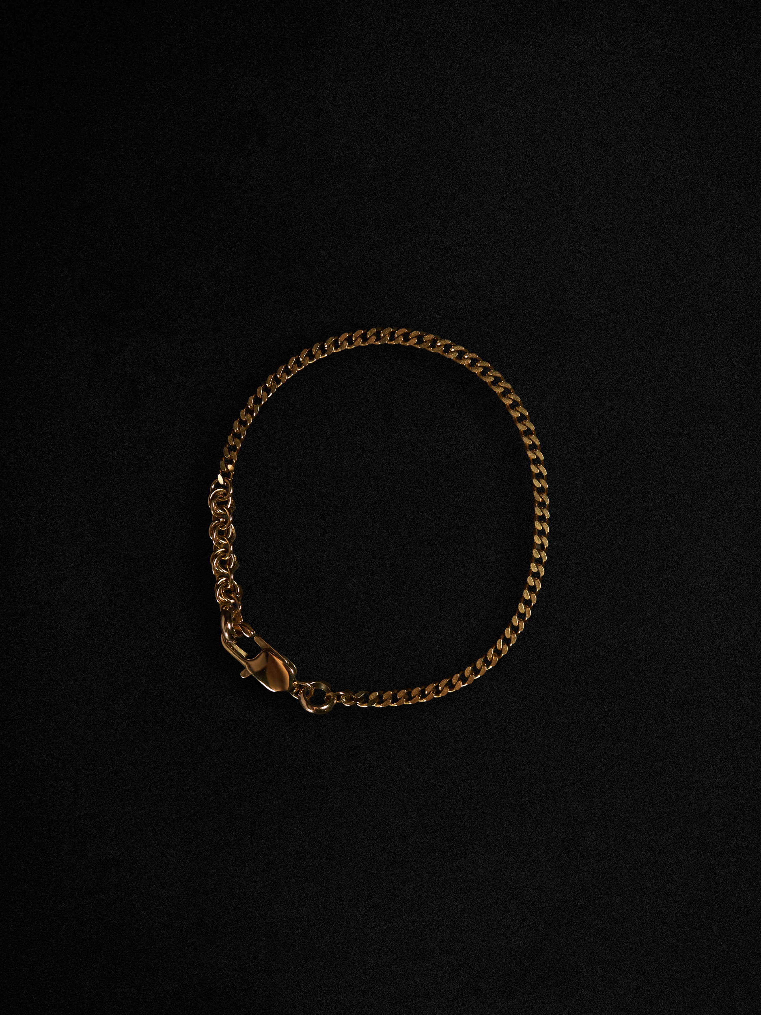Gold chain bracelet on a black background