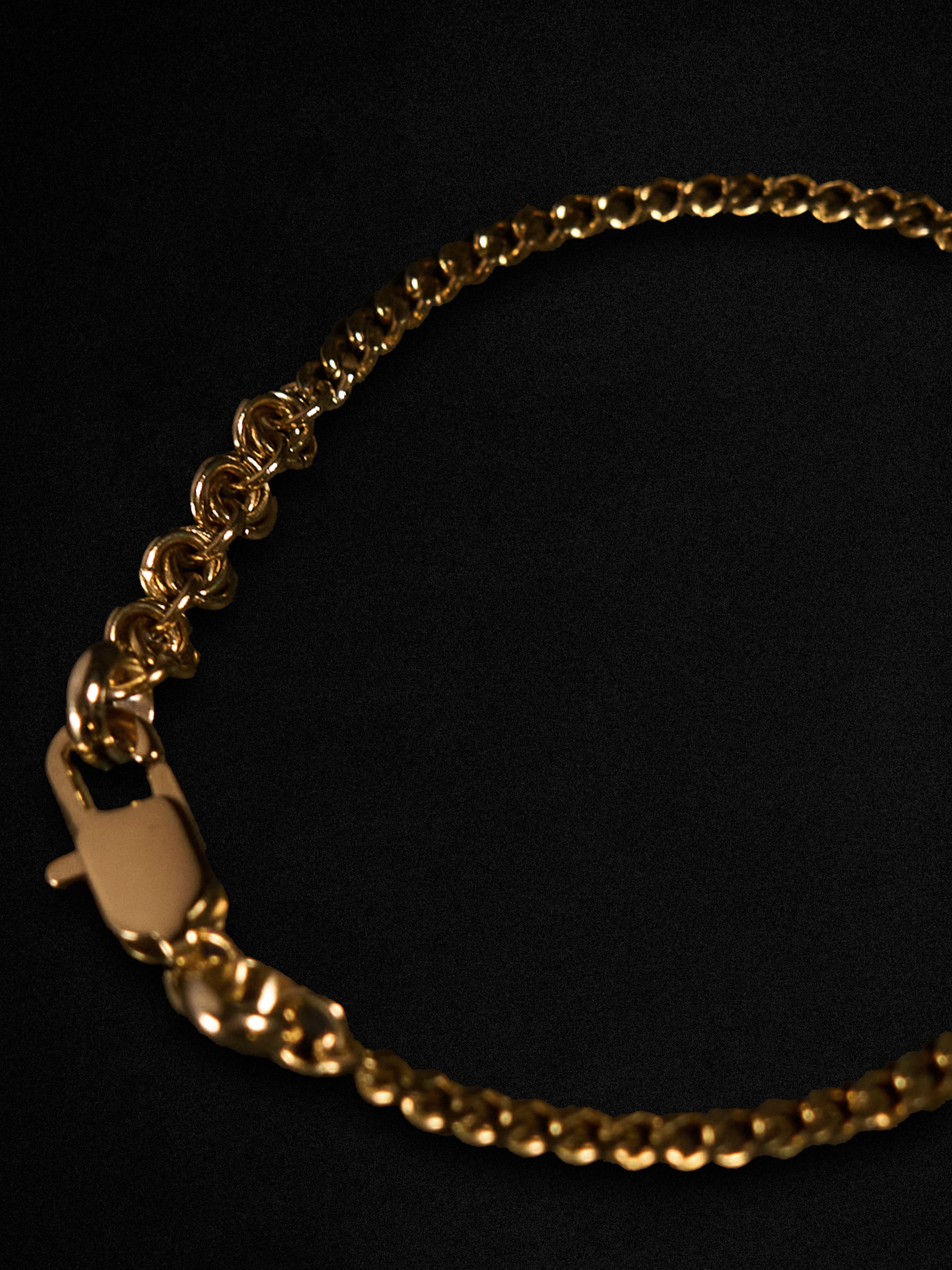 Gold chain bracelet on a black background