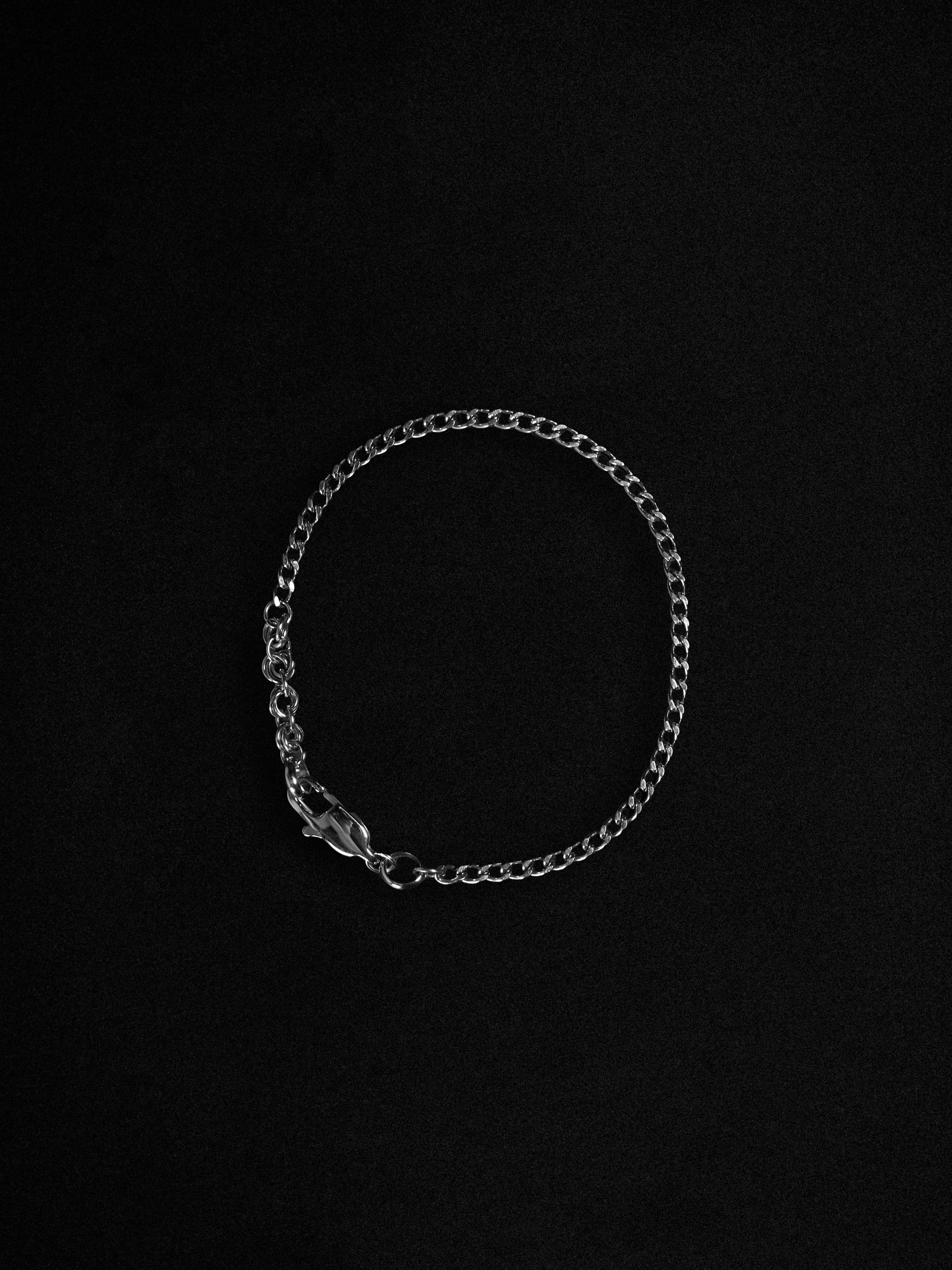 Silver chain bracelet on a black background