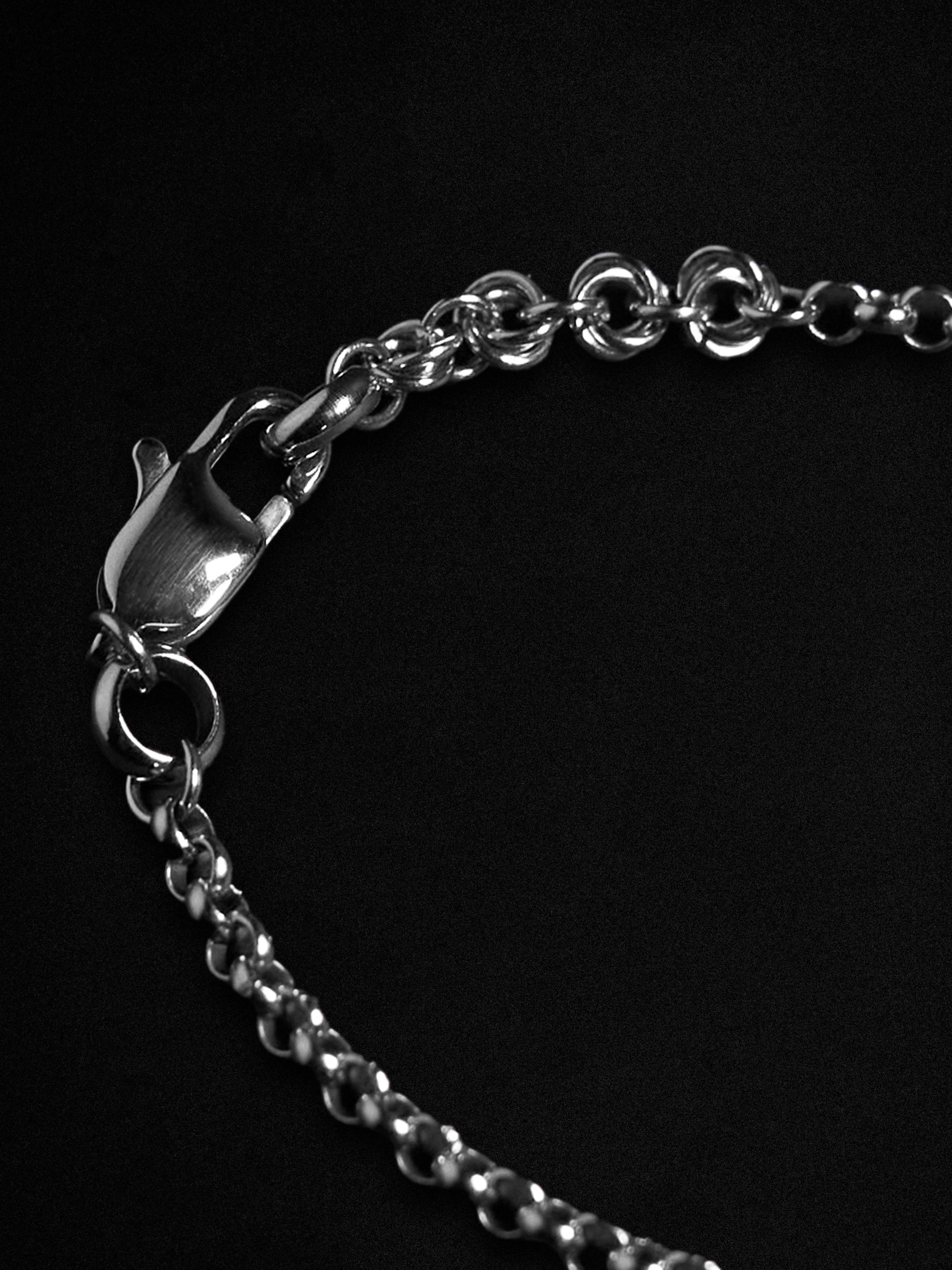 Close-up of a silver chain bracelet on a black background