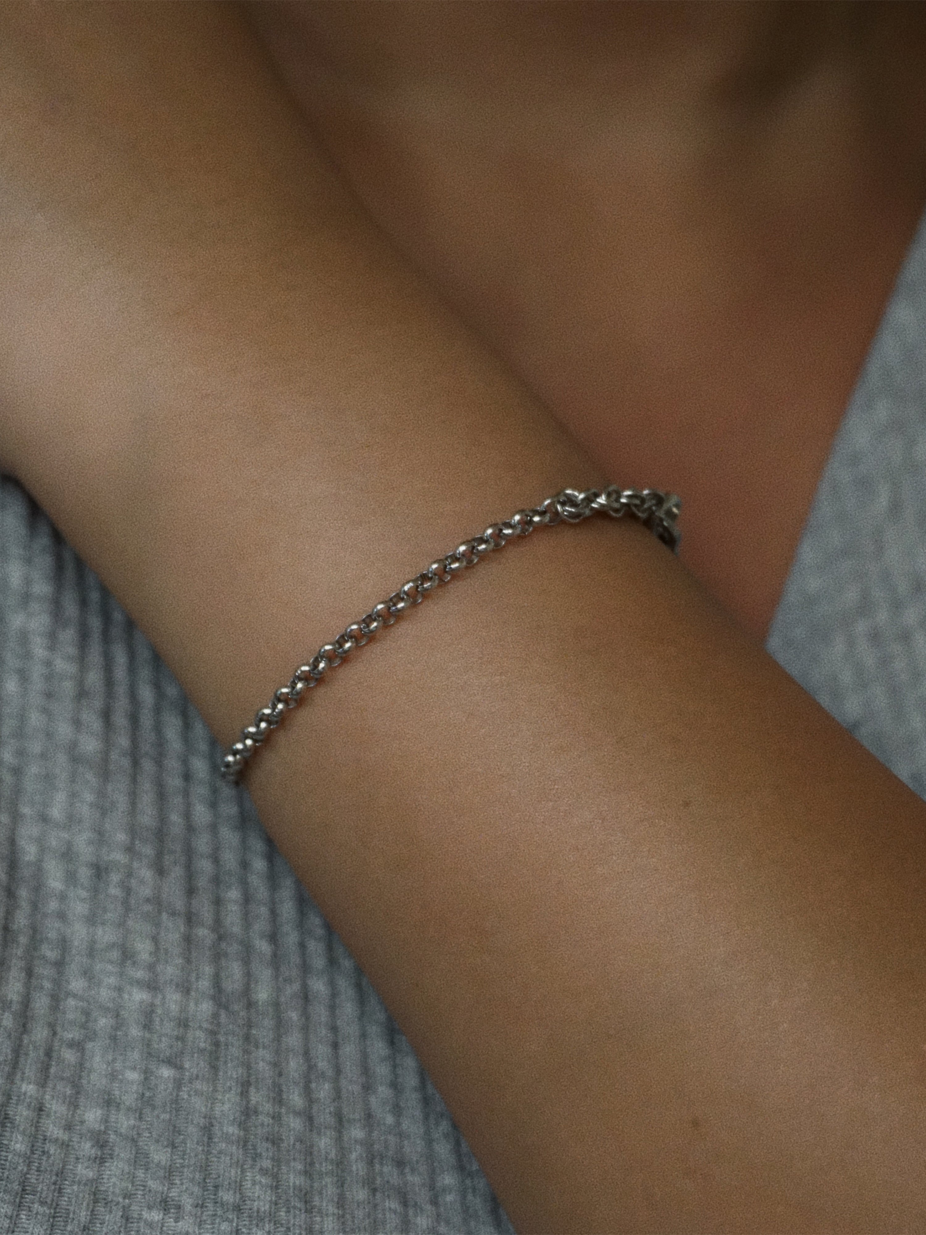 Silver bracelet on a wrist with a blurred background