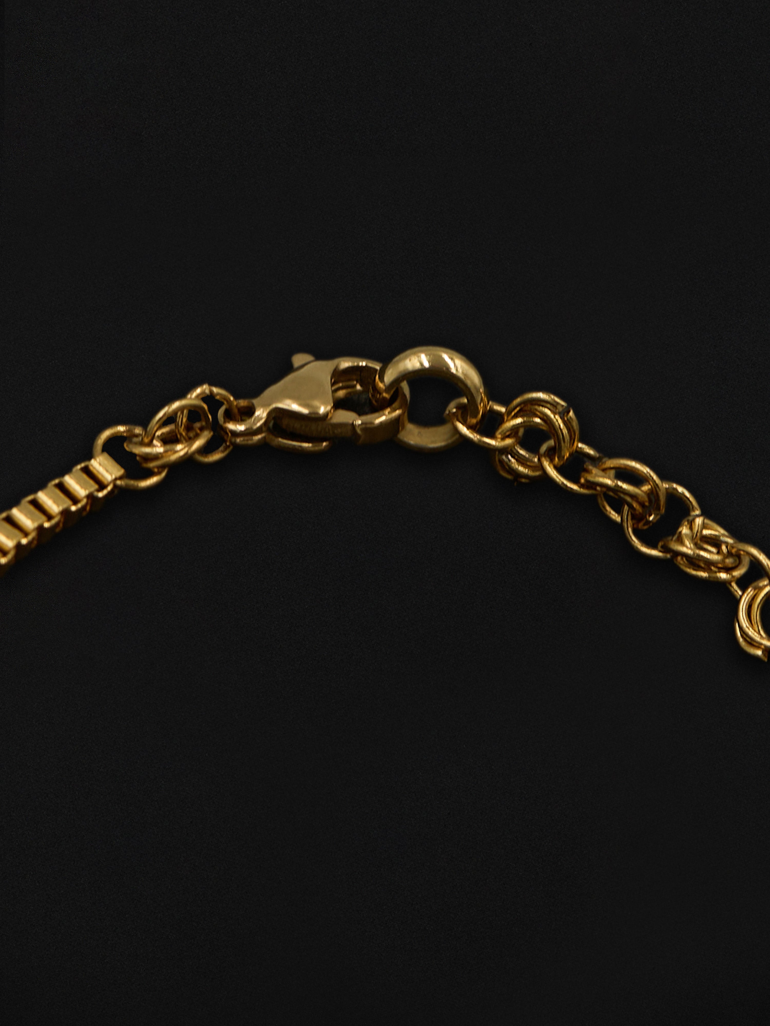 Gold chain bracelet on a black background