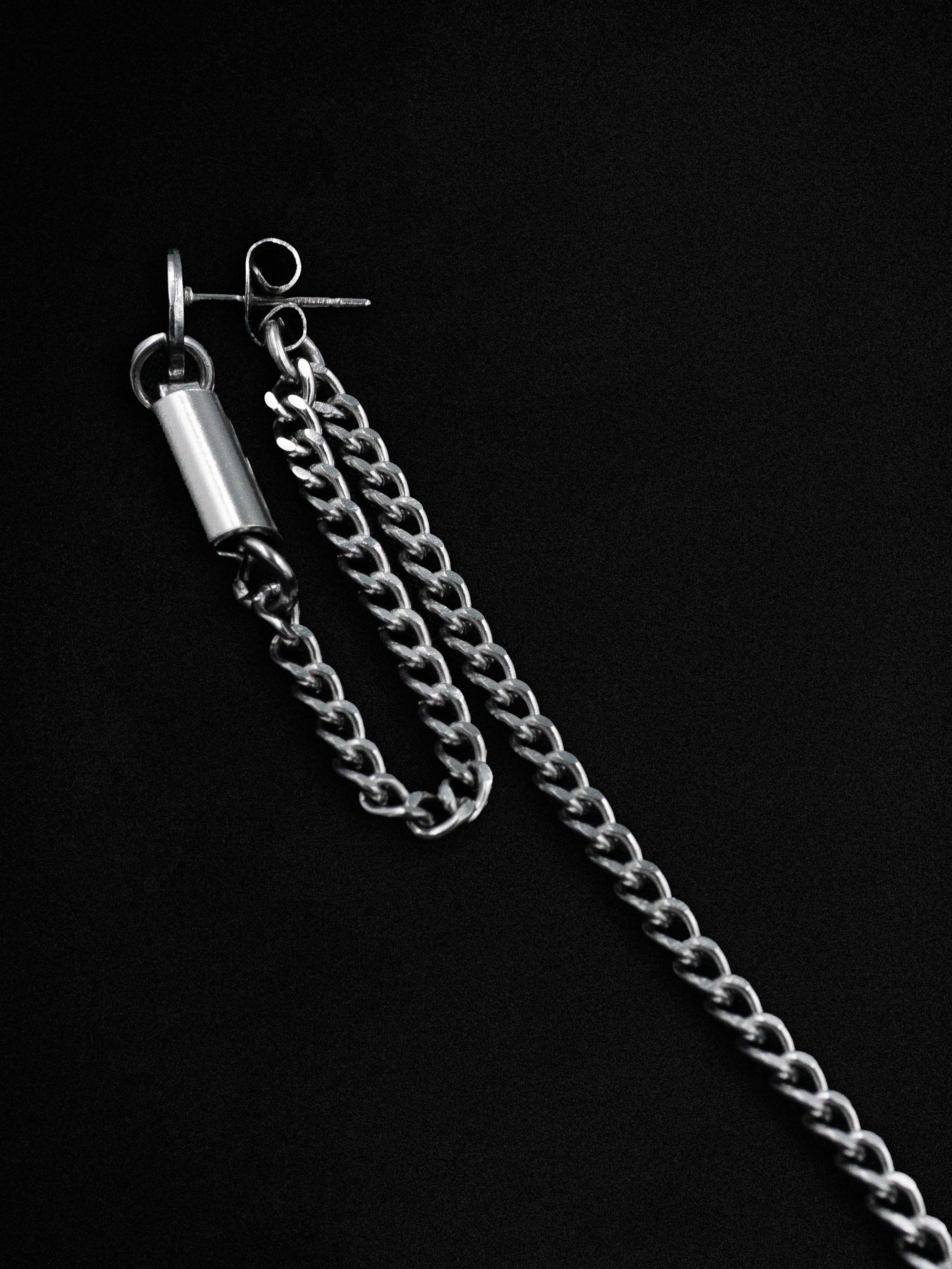 Silver chain earrings on a black background
