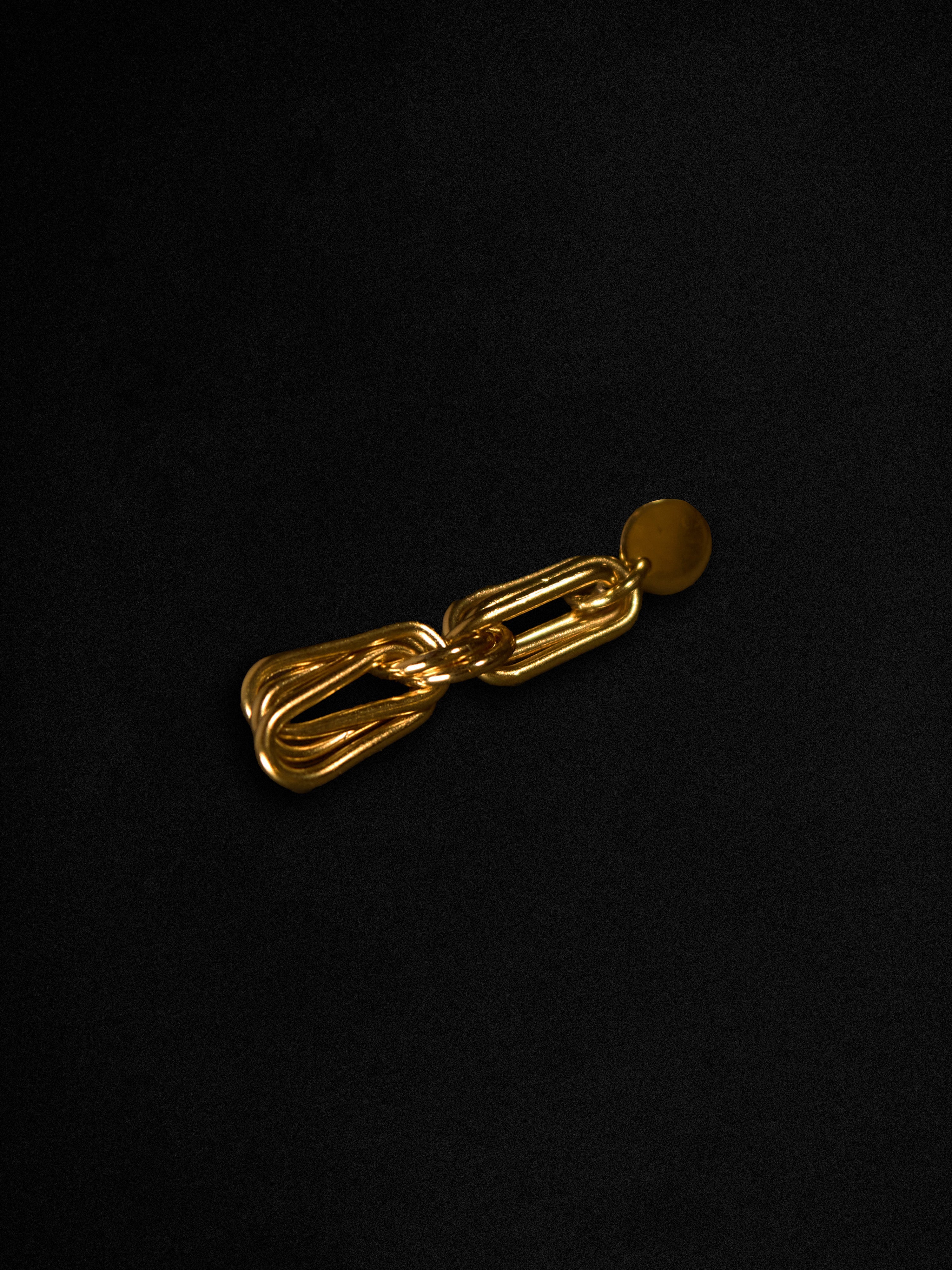 Gold chain earring on a black background