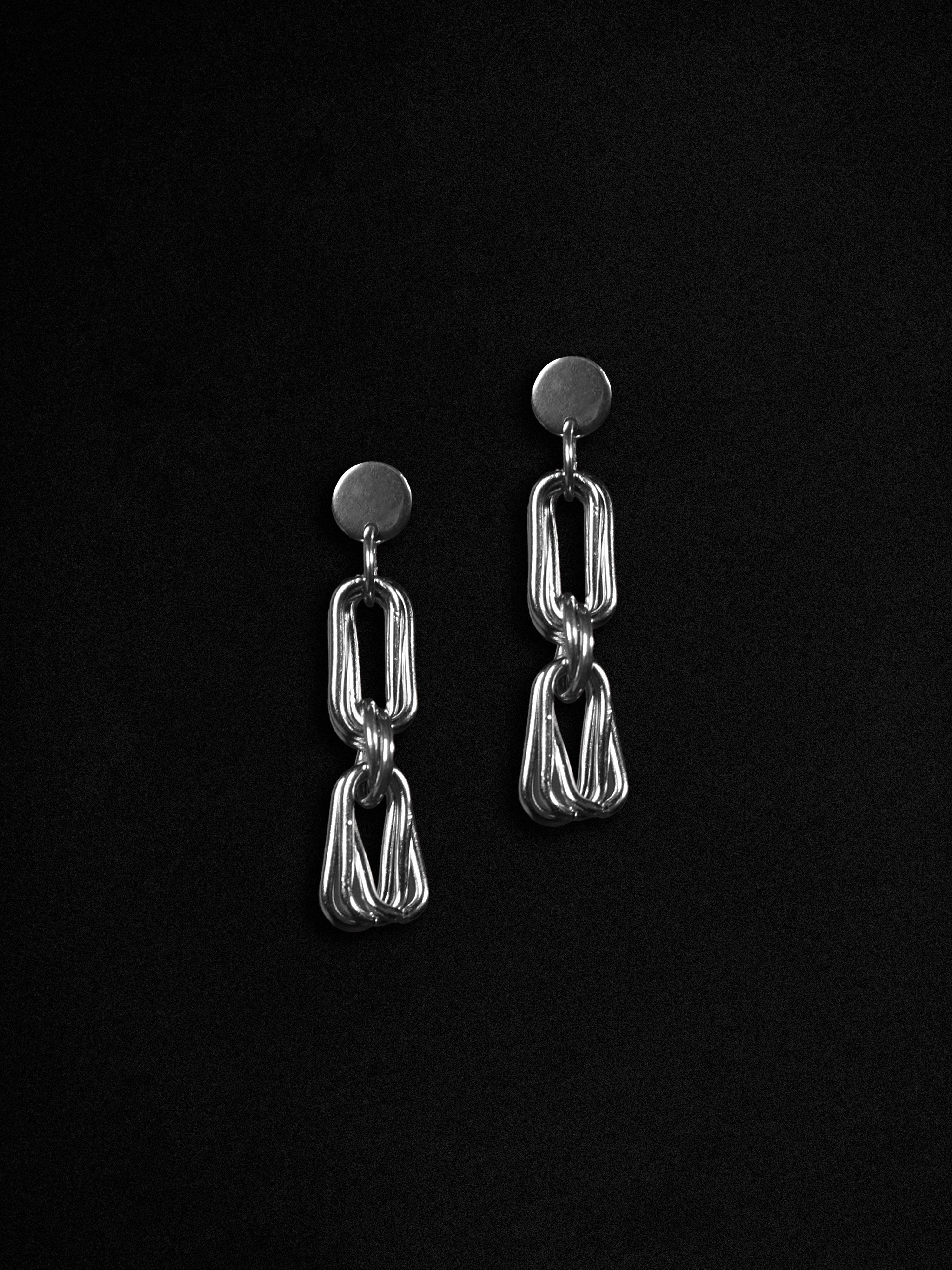 Pair of silver chain-link earrings on a black background