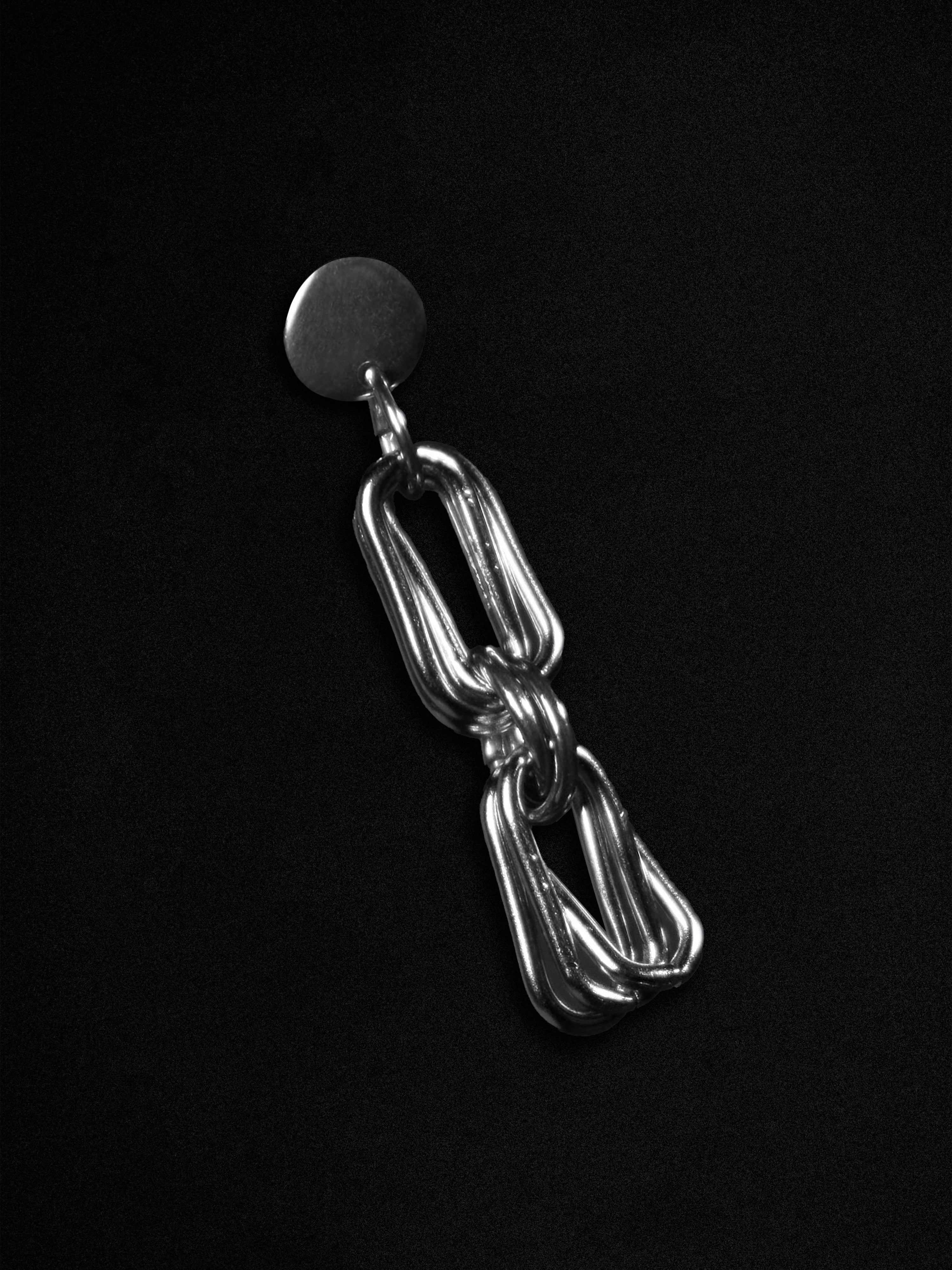 Silver chain earring on a black background