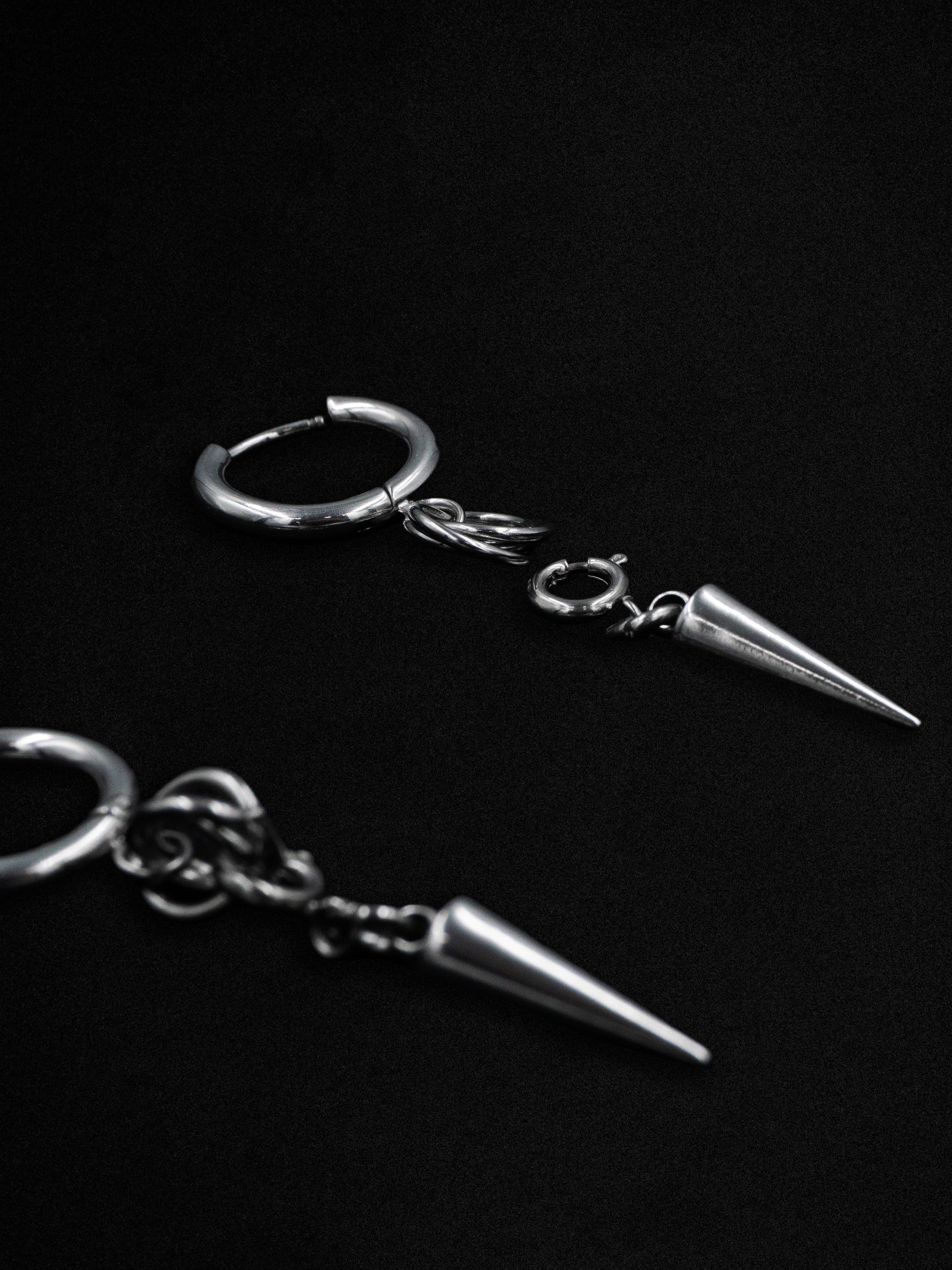 Silver spike earrings on a black background