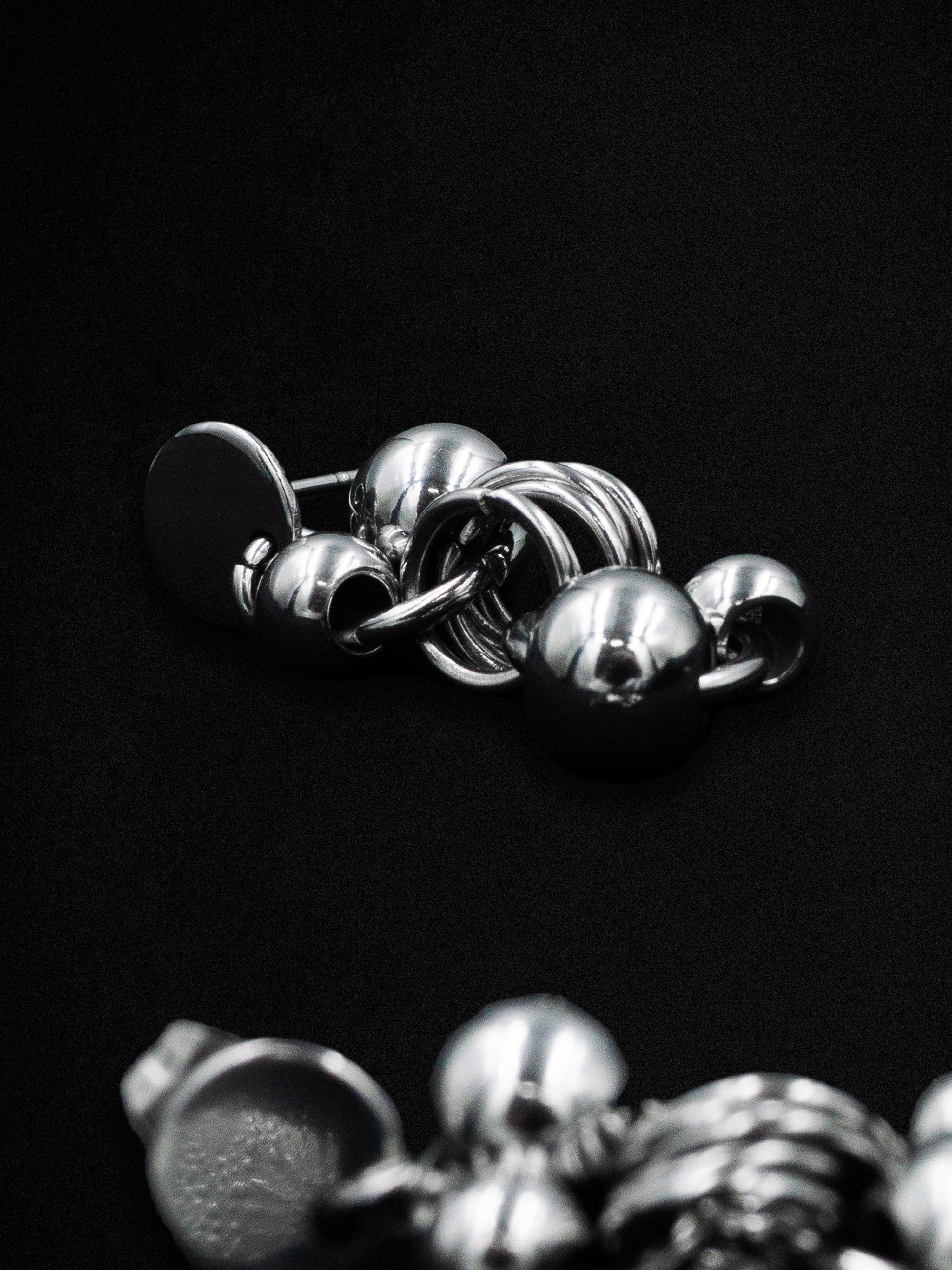 Close-up of metallic earrings on a dark background