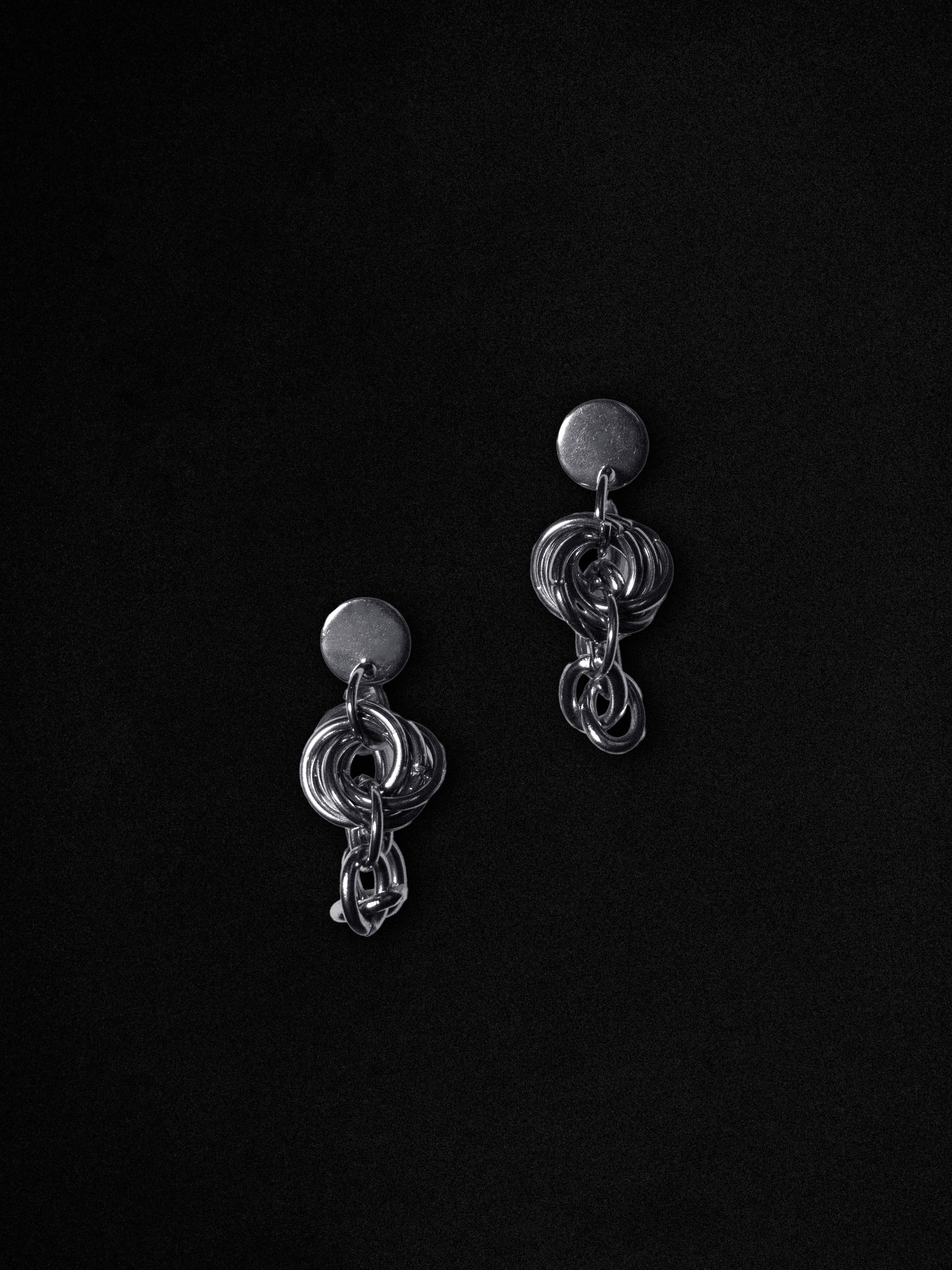 Pair of silver earrings on a black background