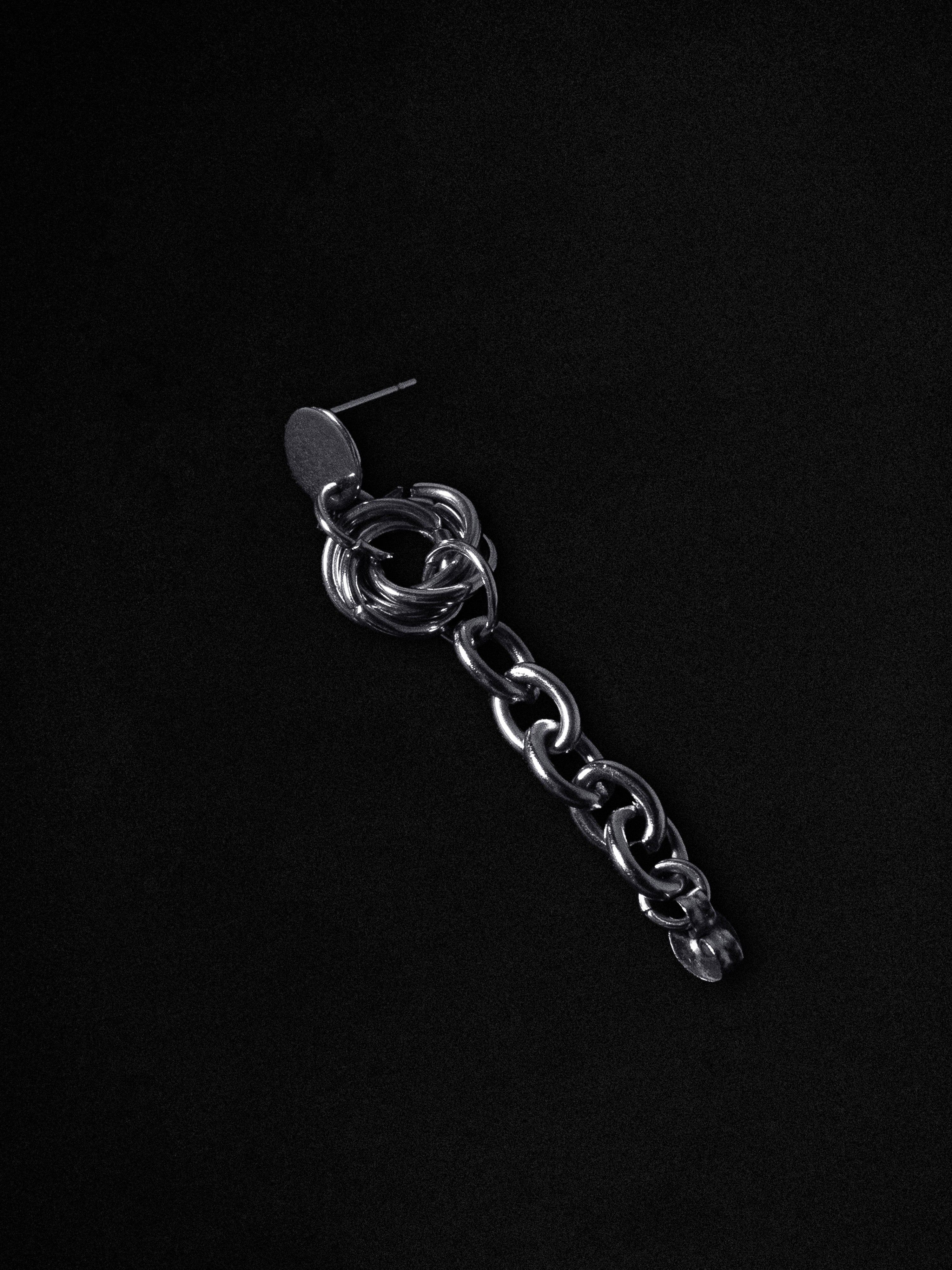 Silver chain earring on a black background