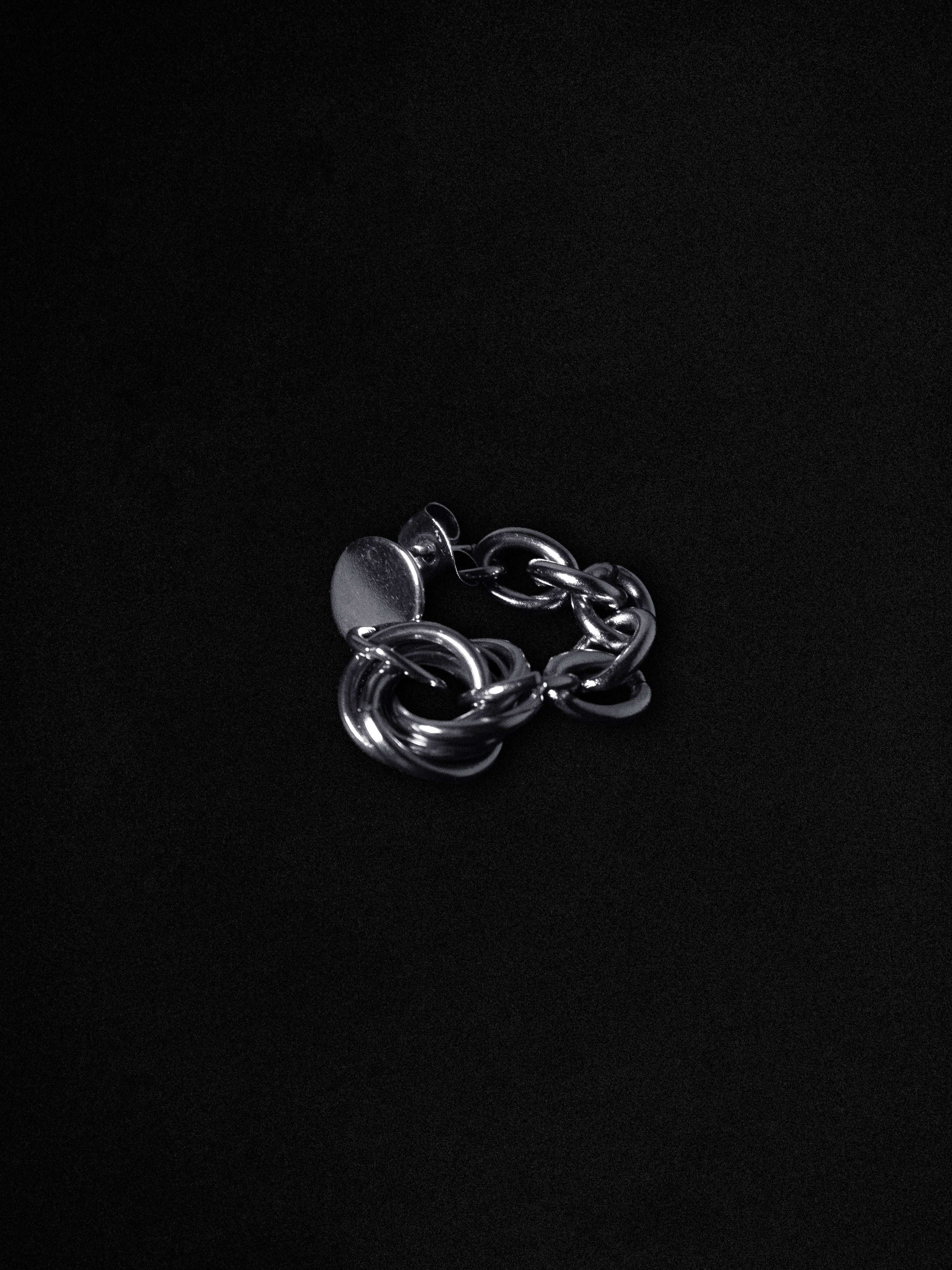 Silver chain earring on a black background