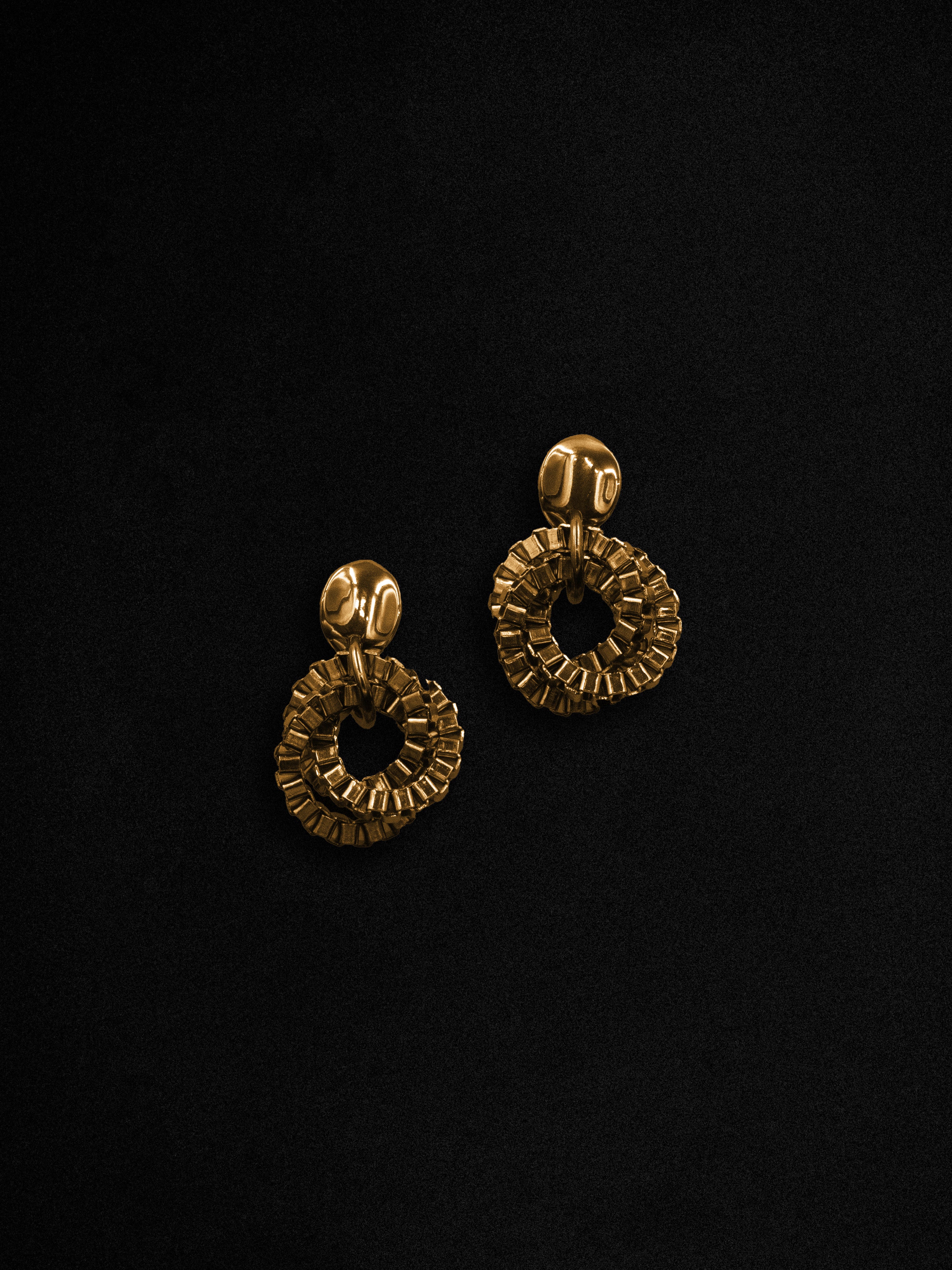 Pair of gold earrings on a black background