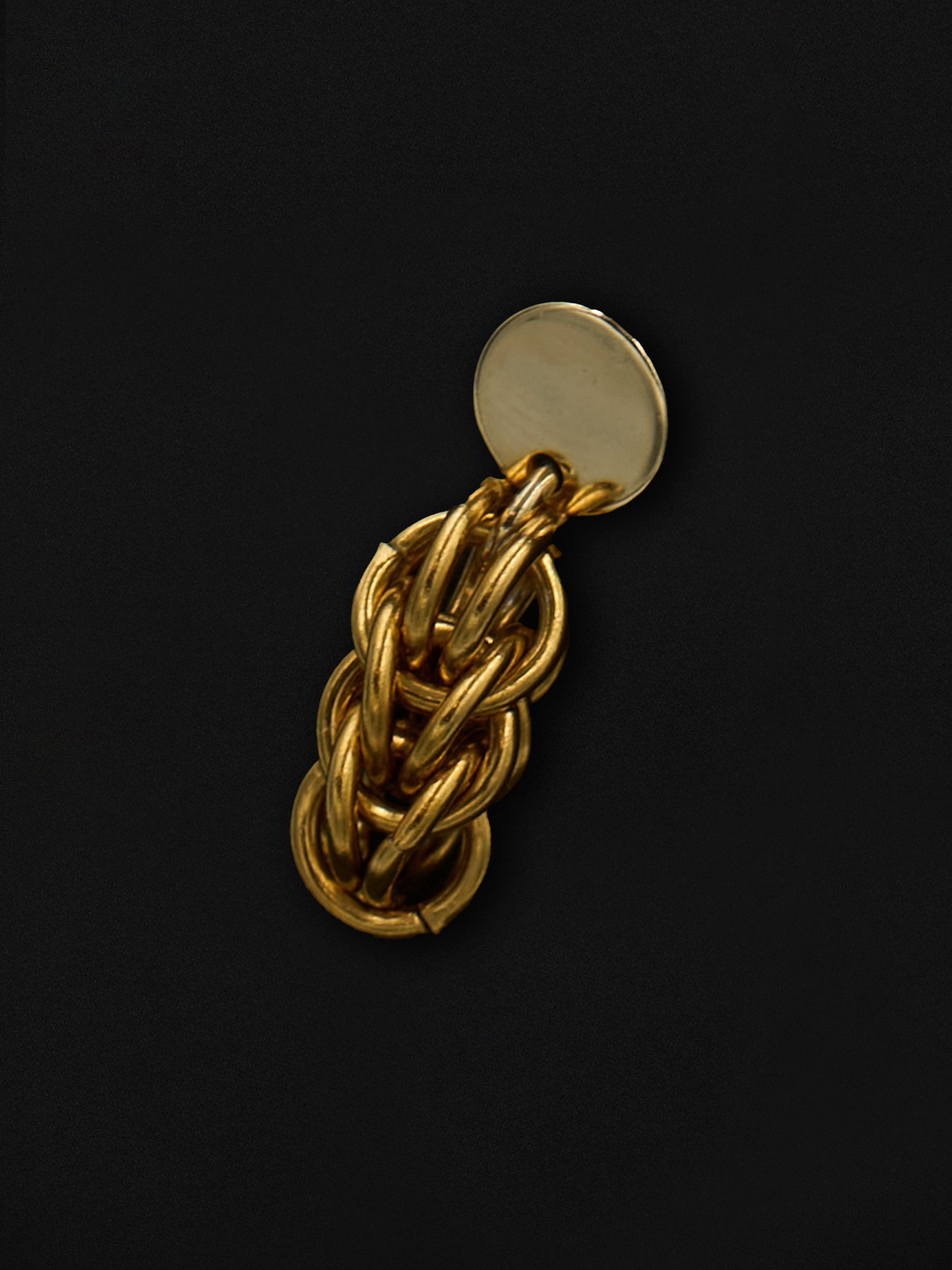 Gold chain earring on a black background