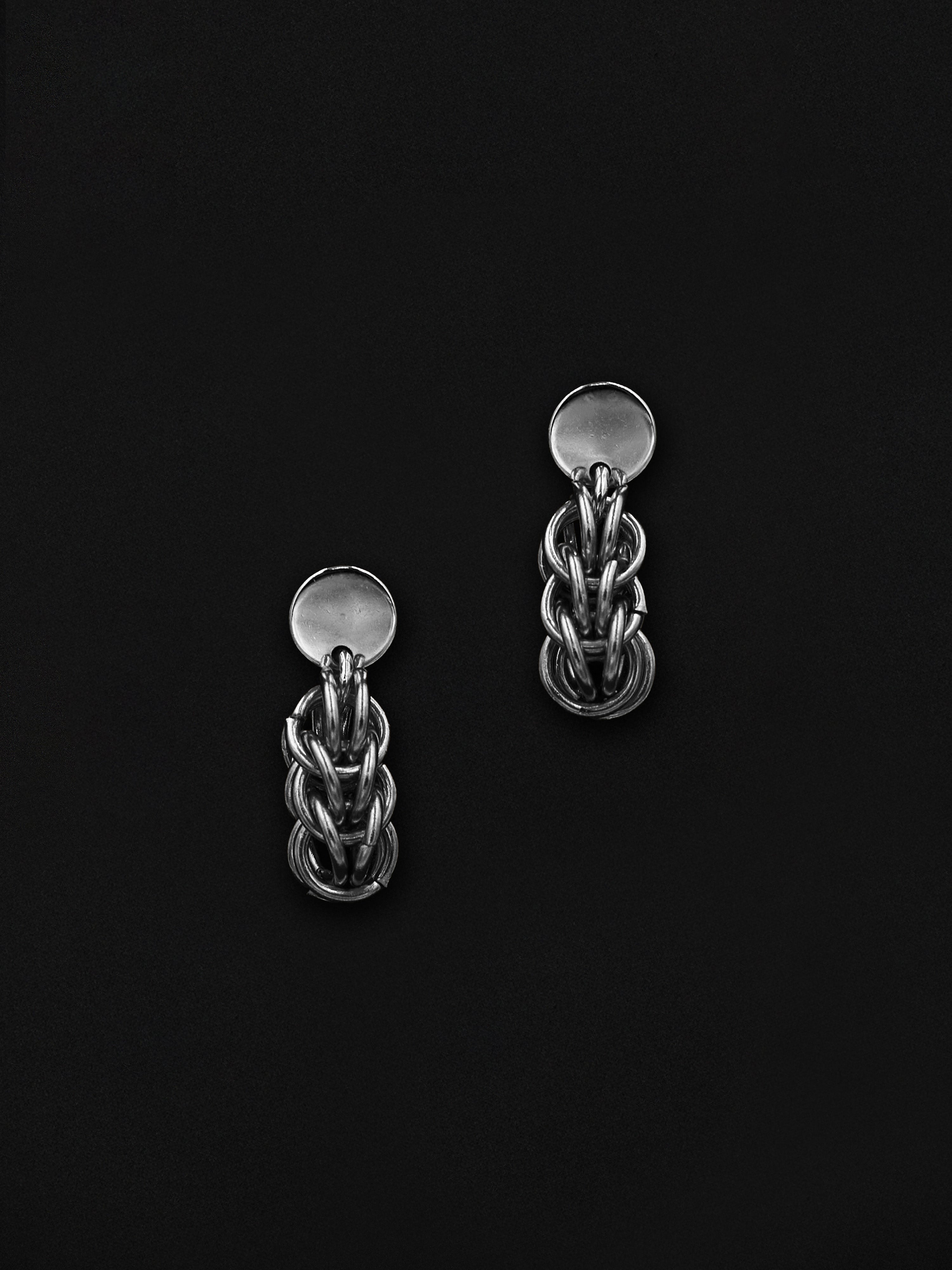 Pair of silver chain earrings on a black background