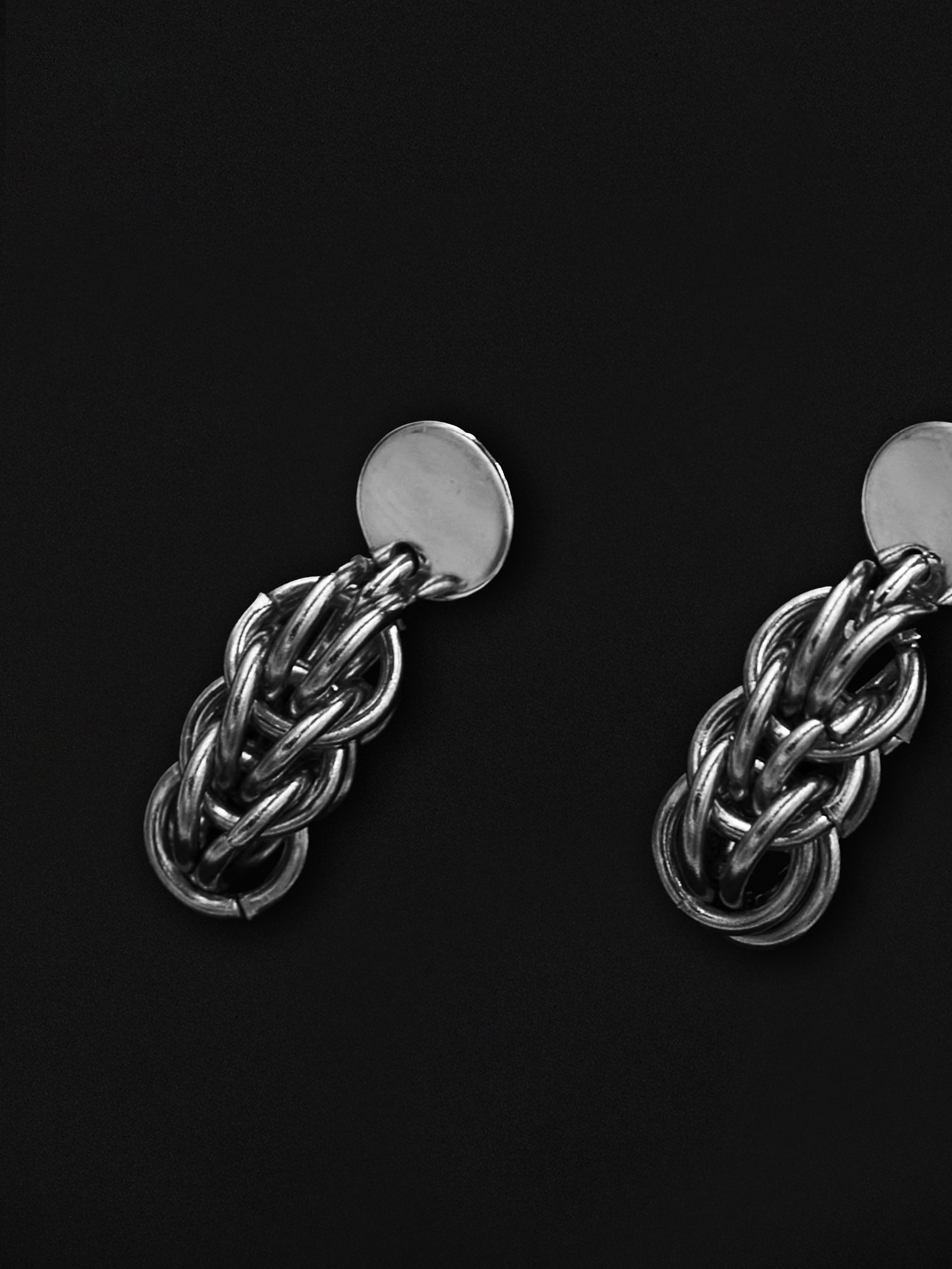 Pair of silver chain earrings on a black background