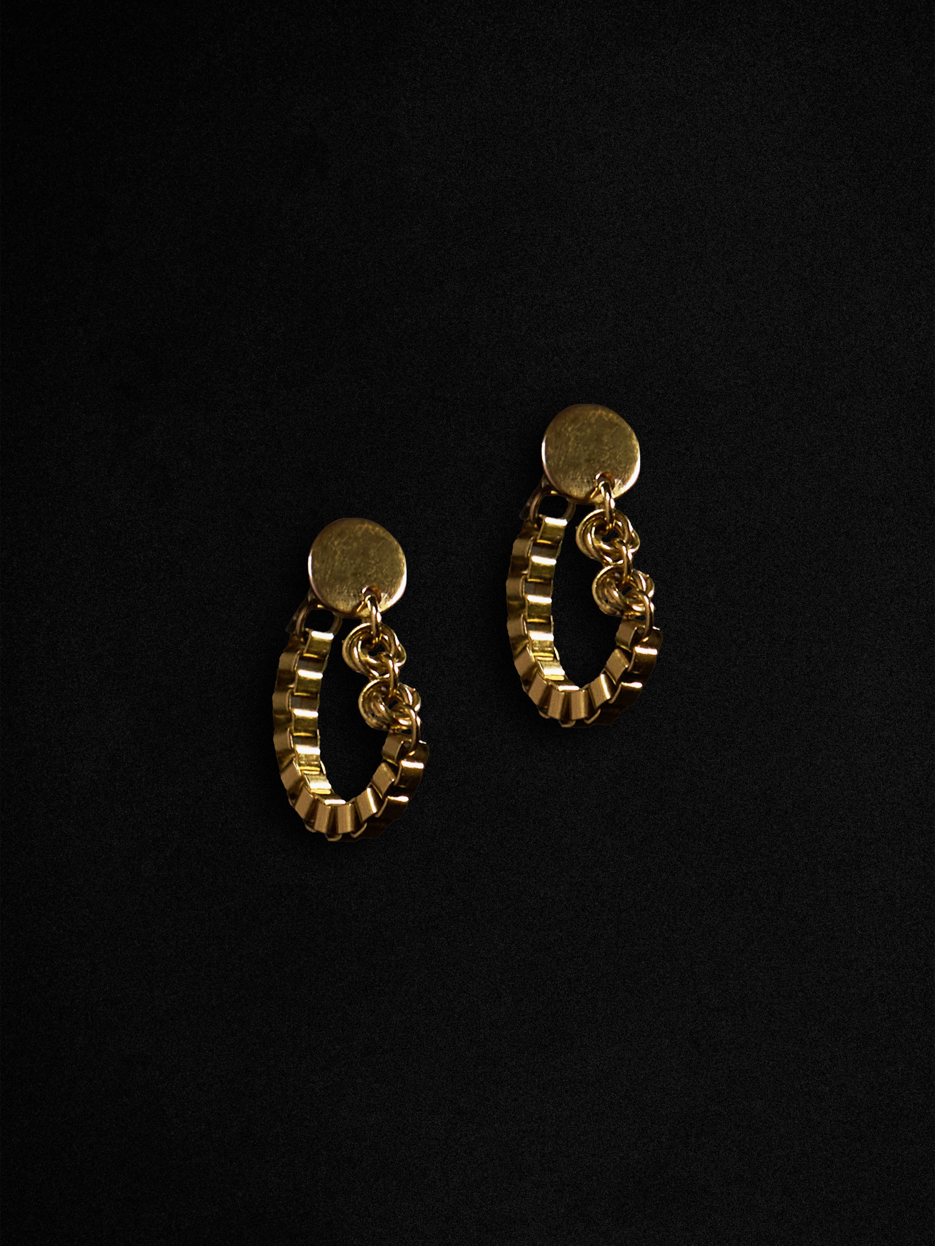 Gold hoop earrings on a black background