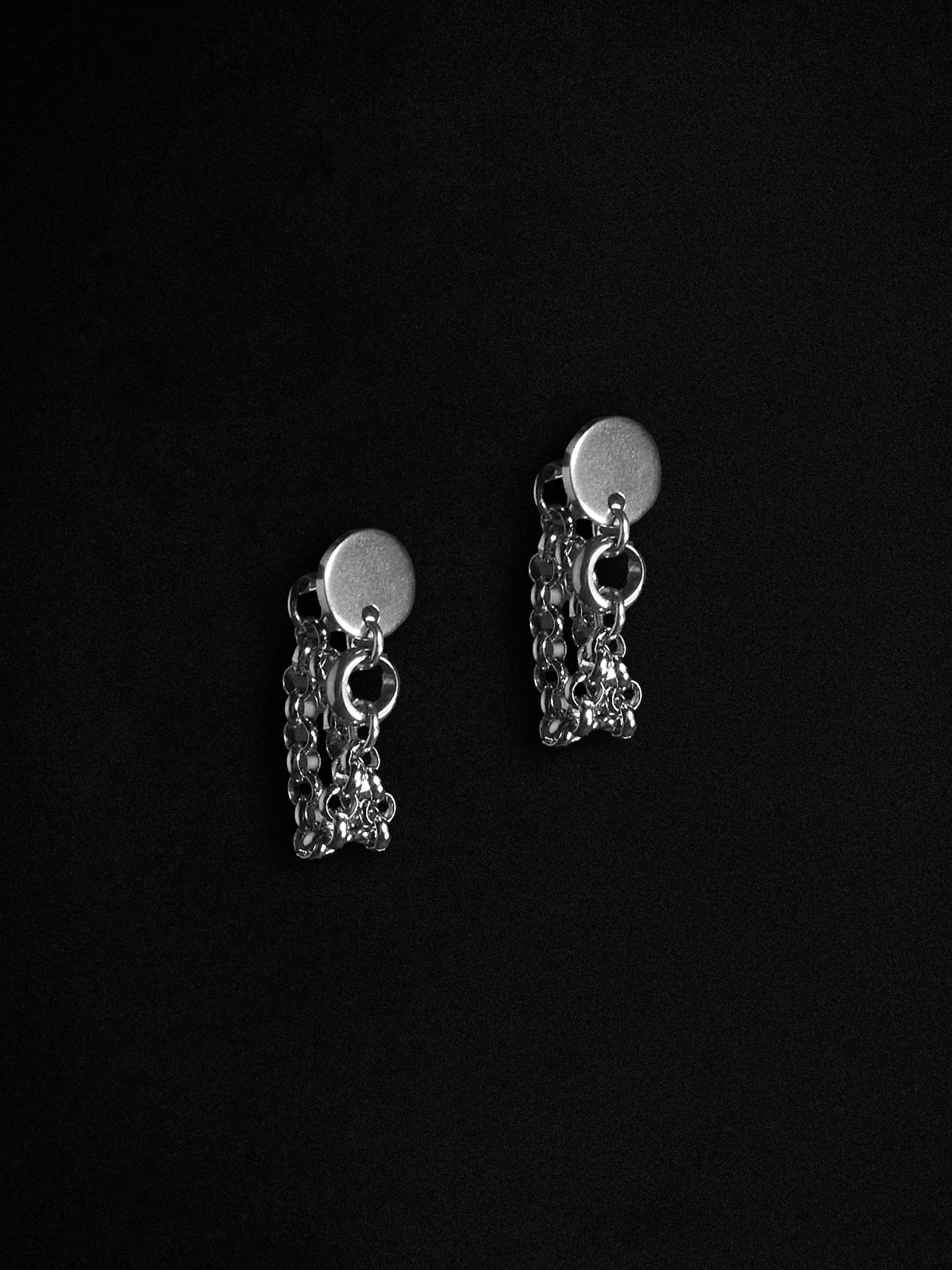 Pair of silver chain earrings on a black background