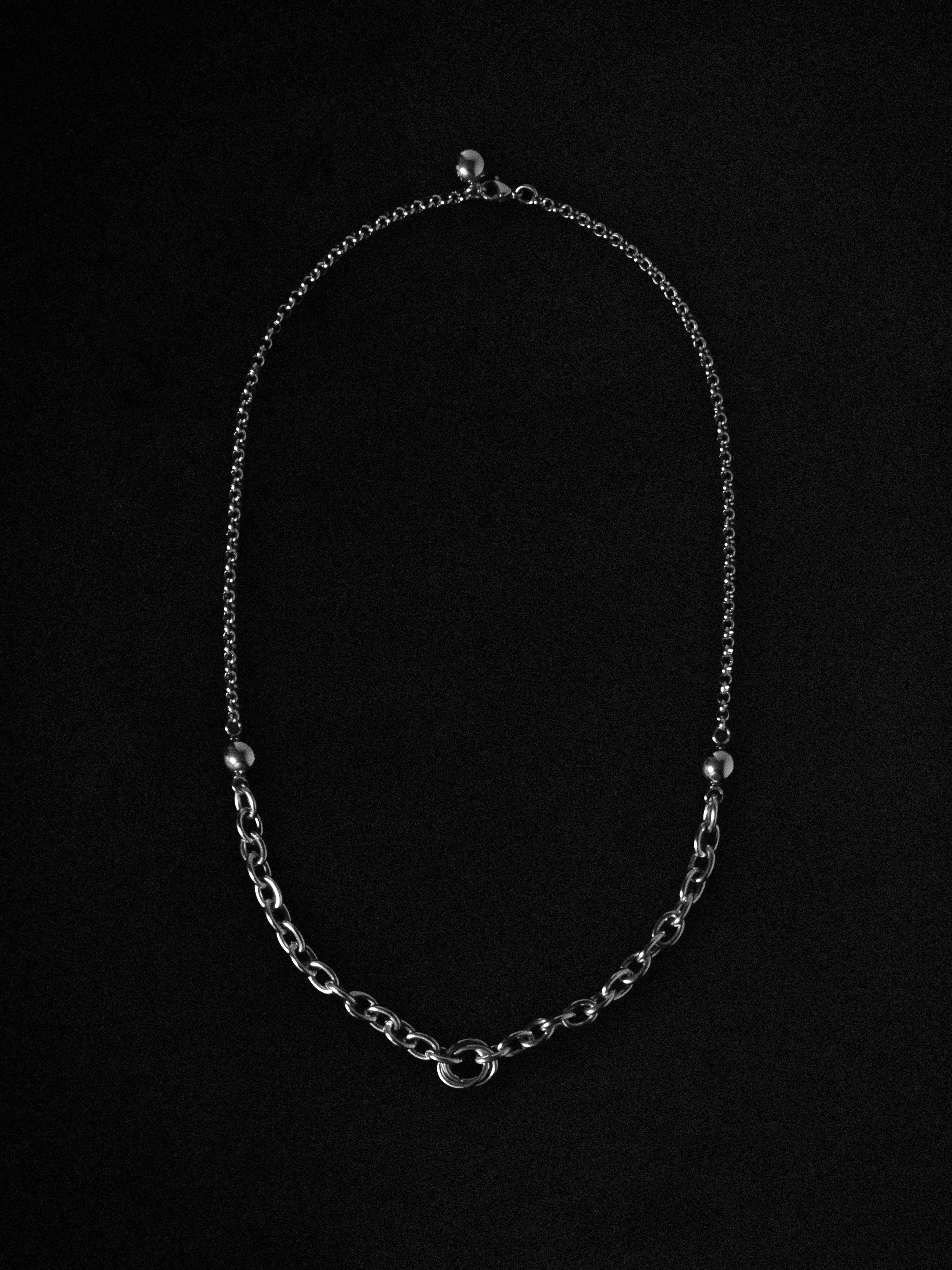 Silver chain necklace on a black background