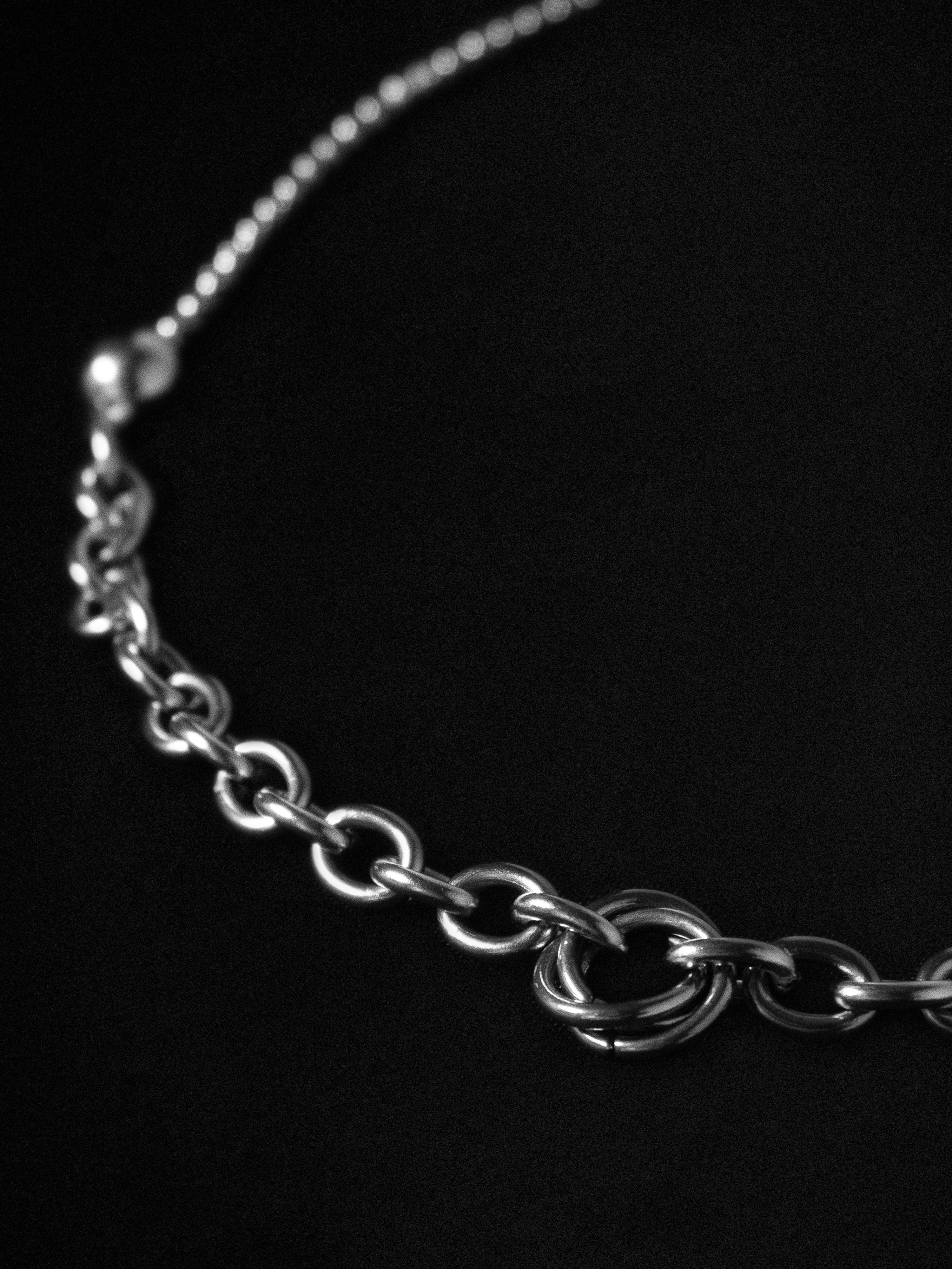 Silver chain necklace close-up on a black background