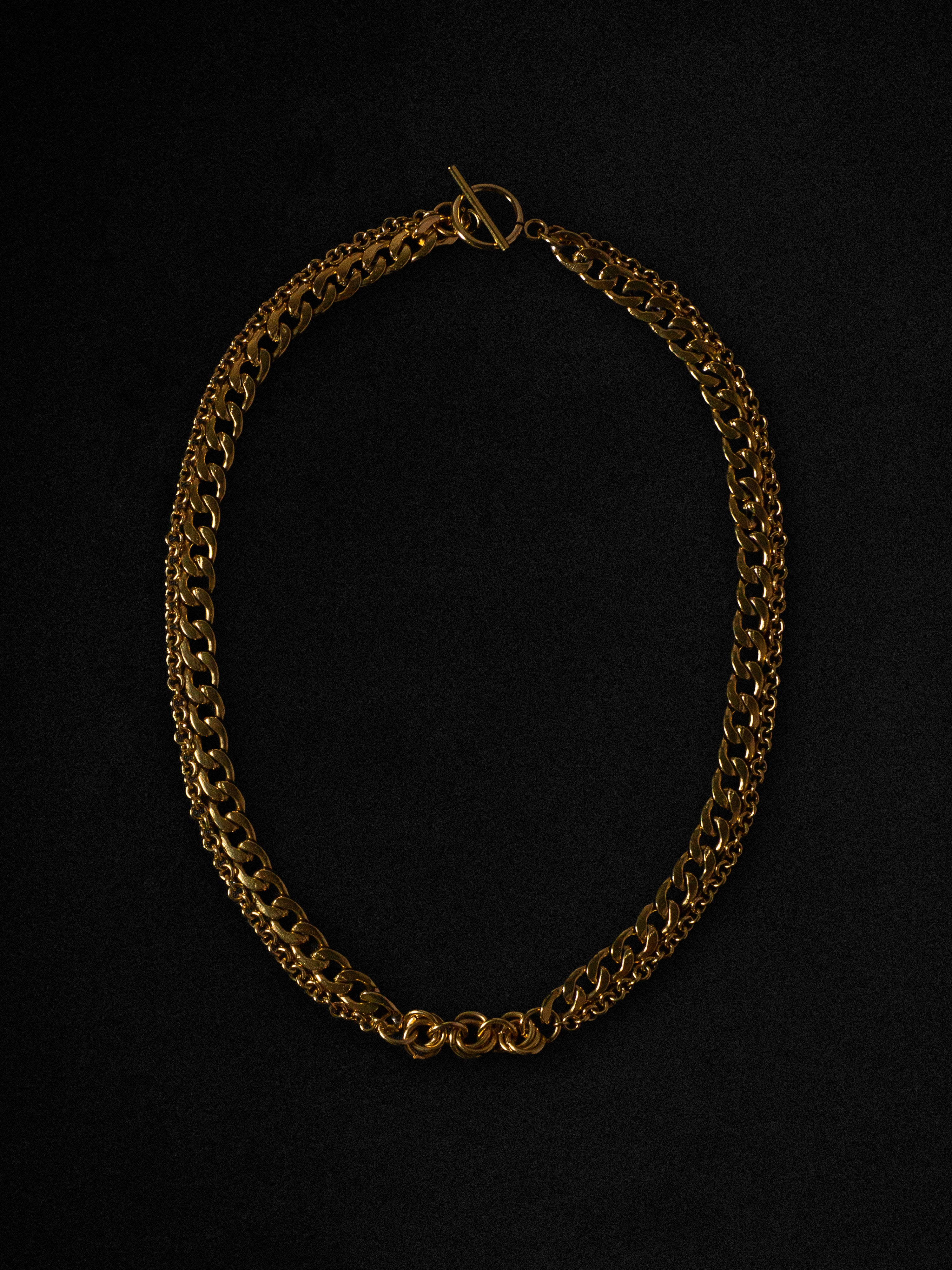 Gold chain necklace on a black background