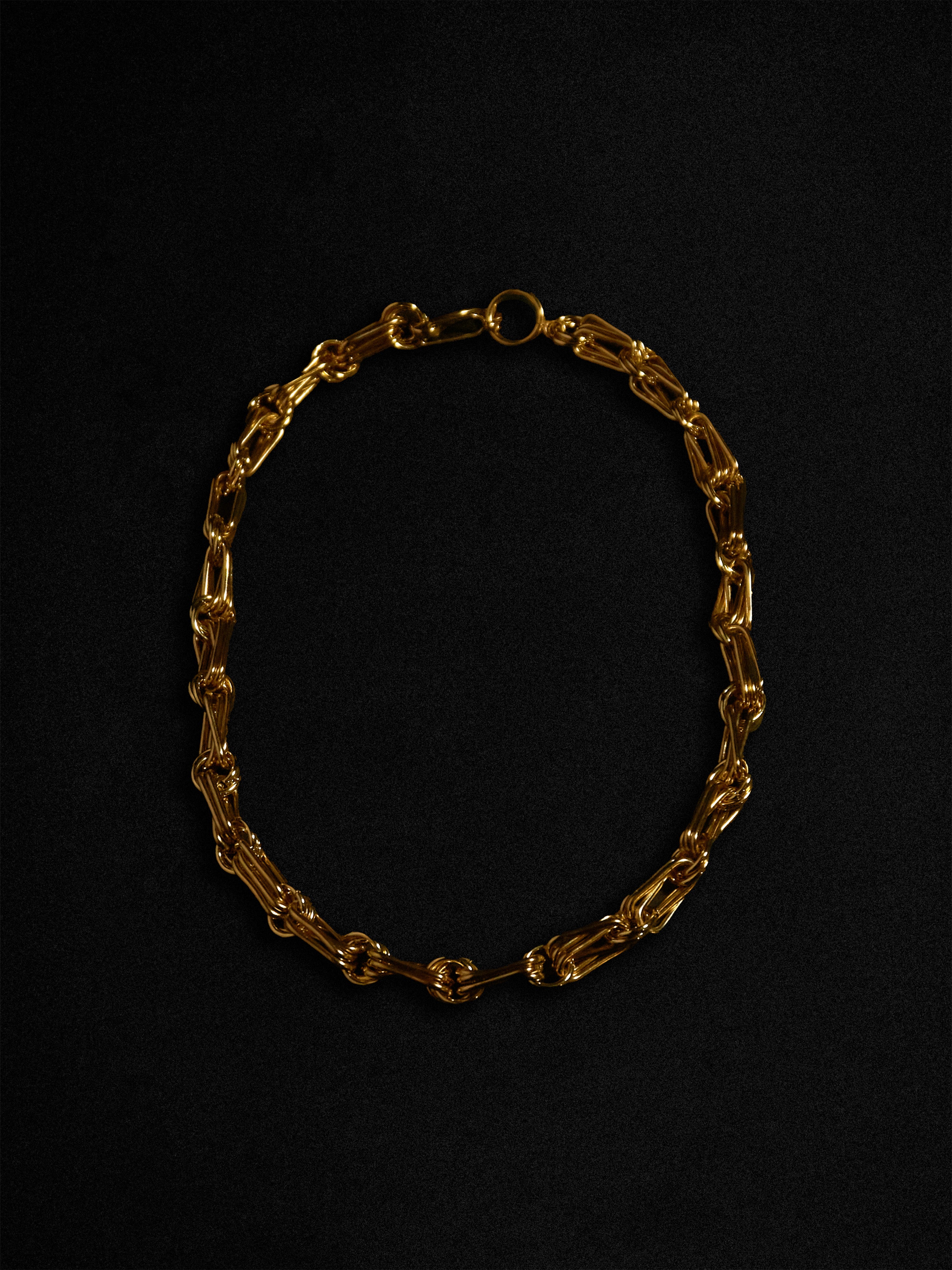 Gold chain necklace on a black background