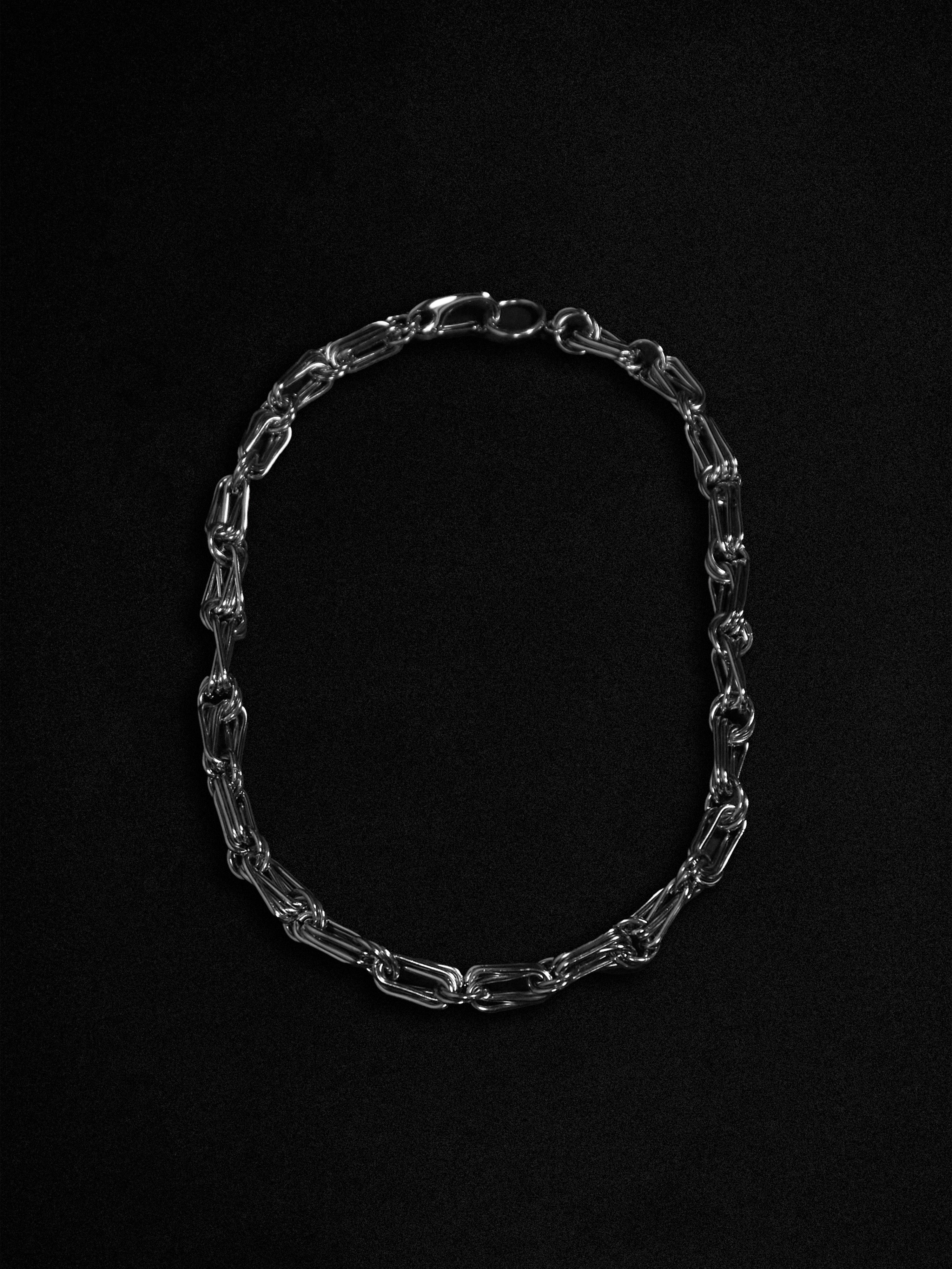 Silver chain necklace on a black background
