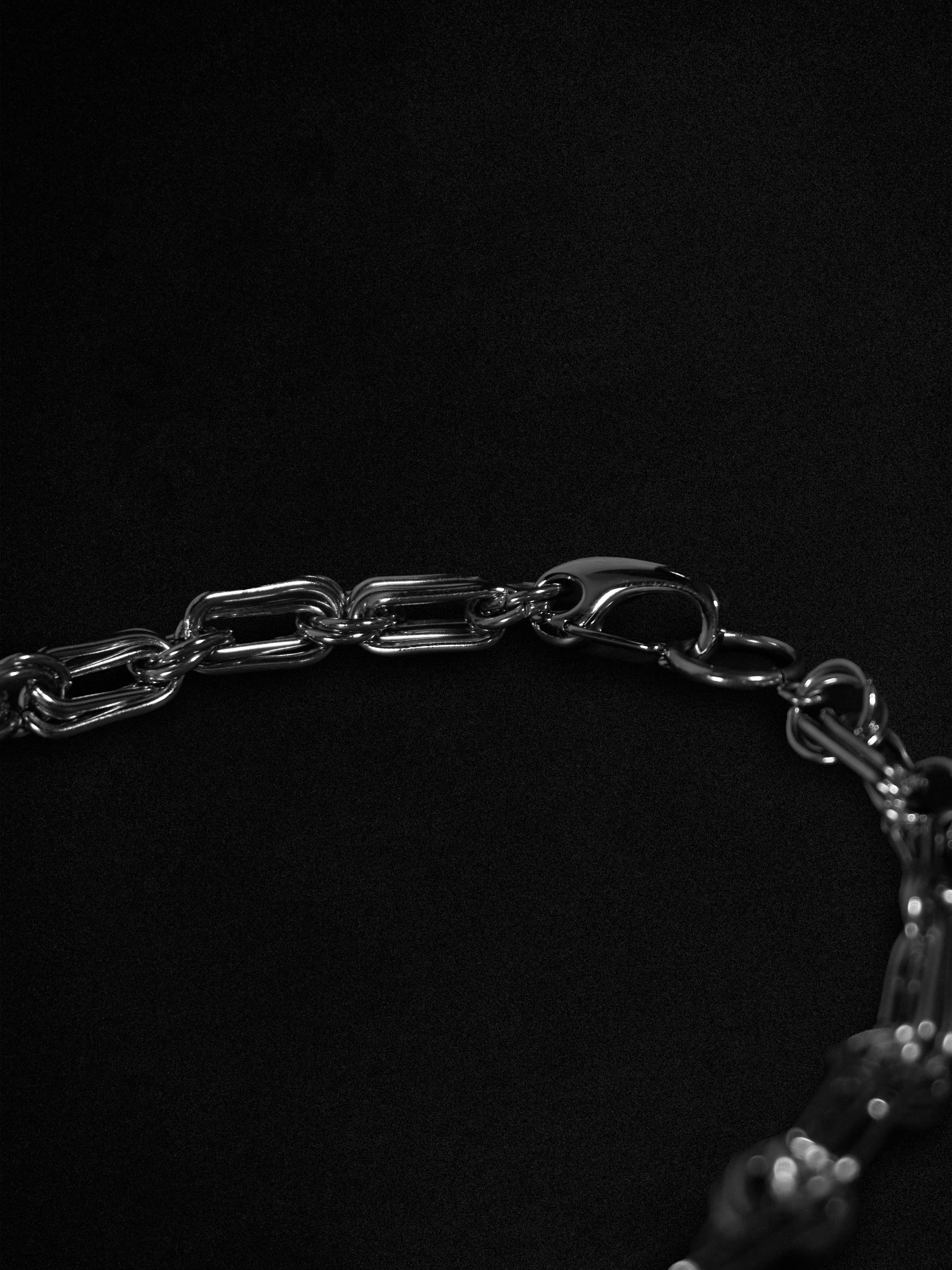 Close-up of a silver chain bracelet on a black background