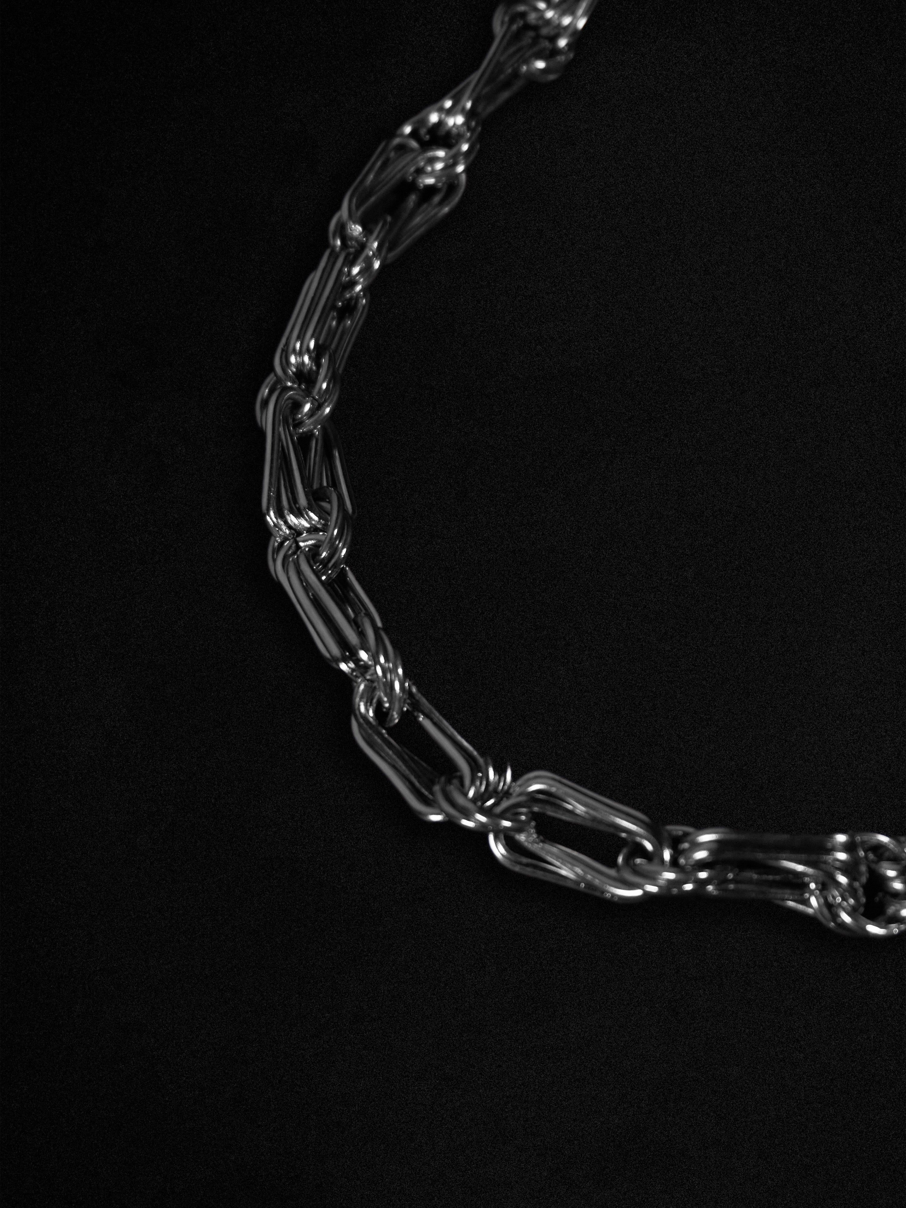 Silver chain necklace on a black background