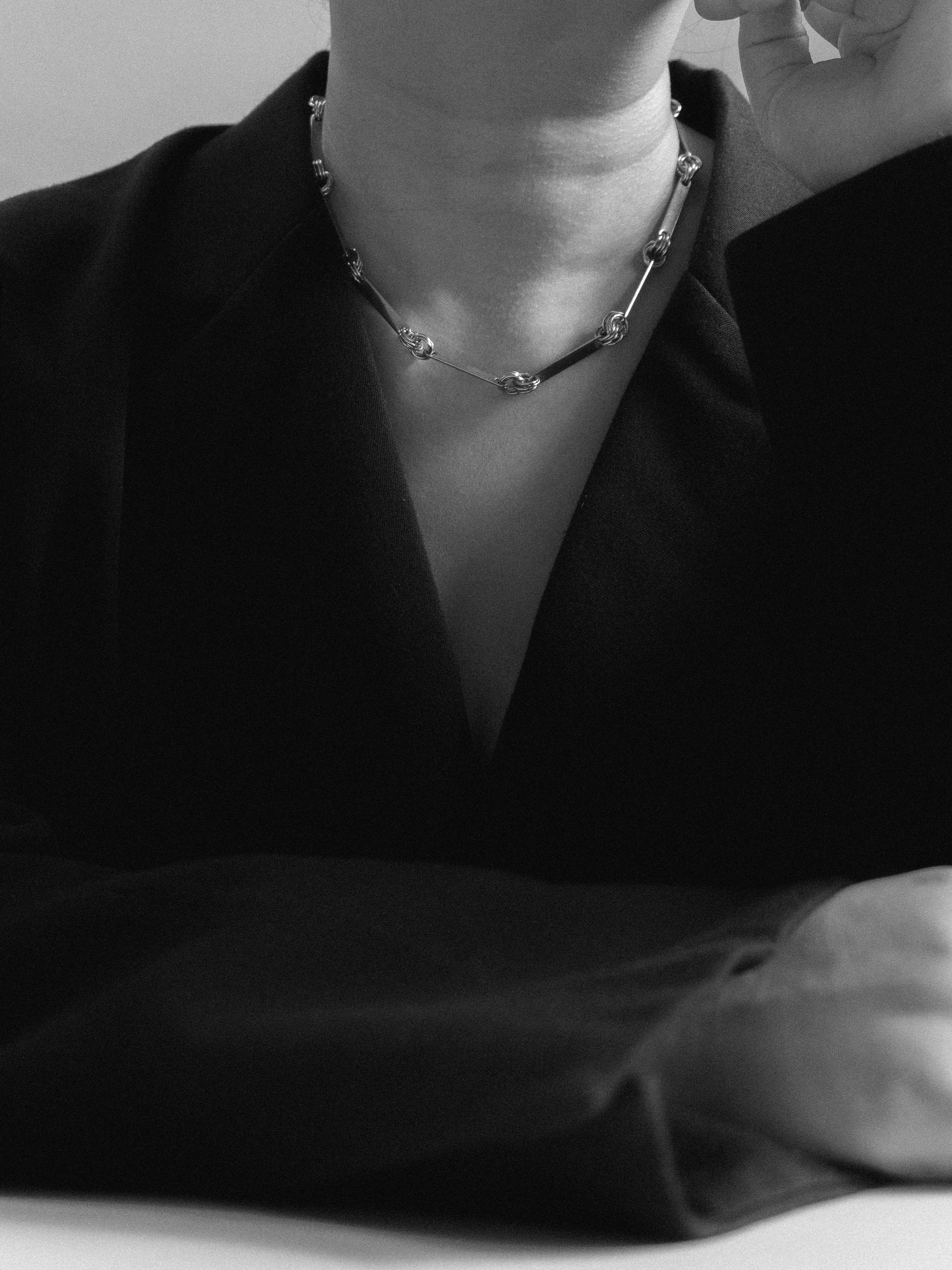 Person wearing a delicate necklace with a blurred background