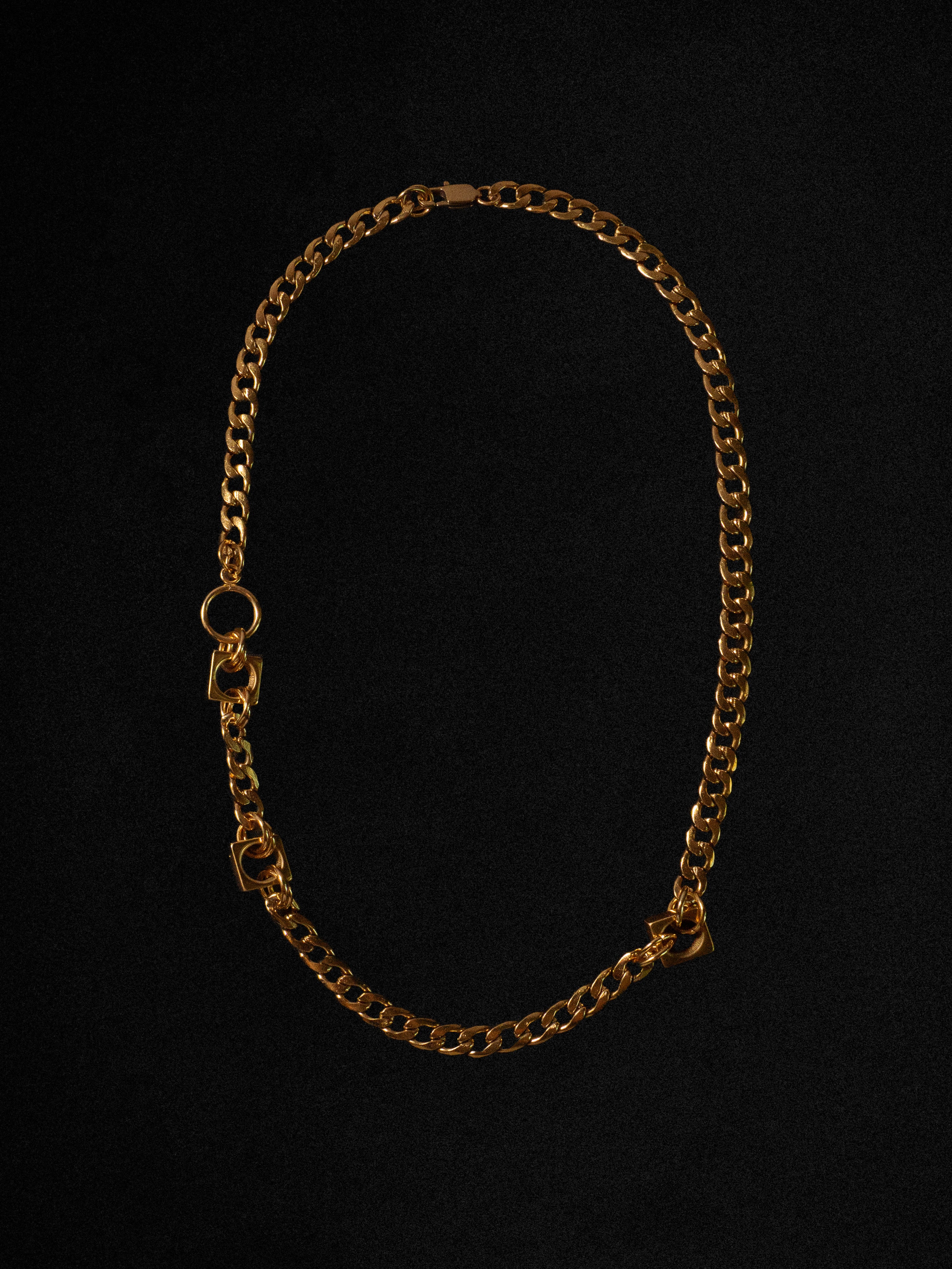 Gold chain necklace on a black background