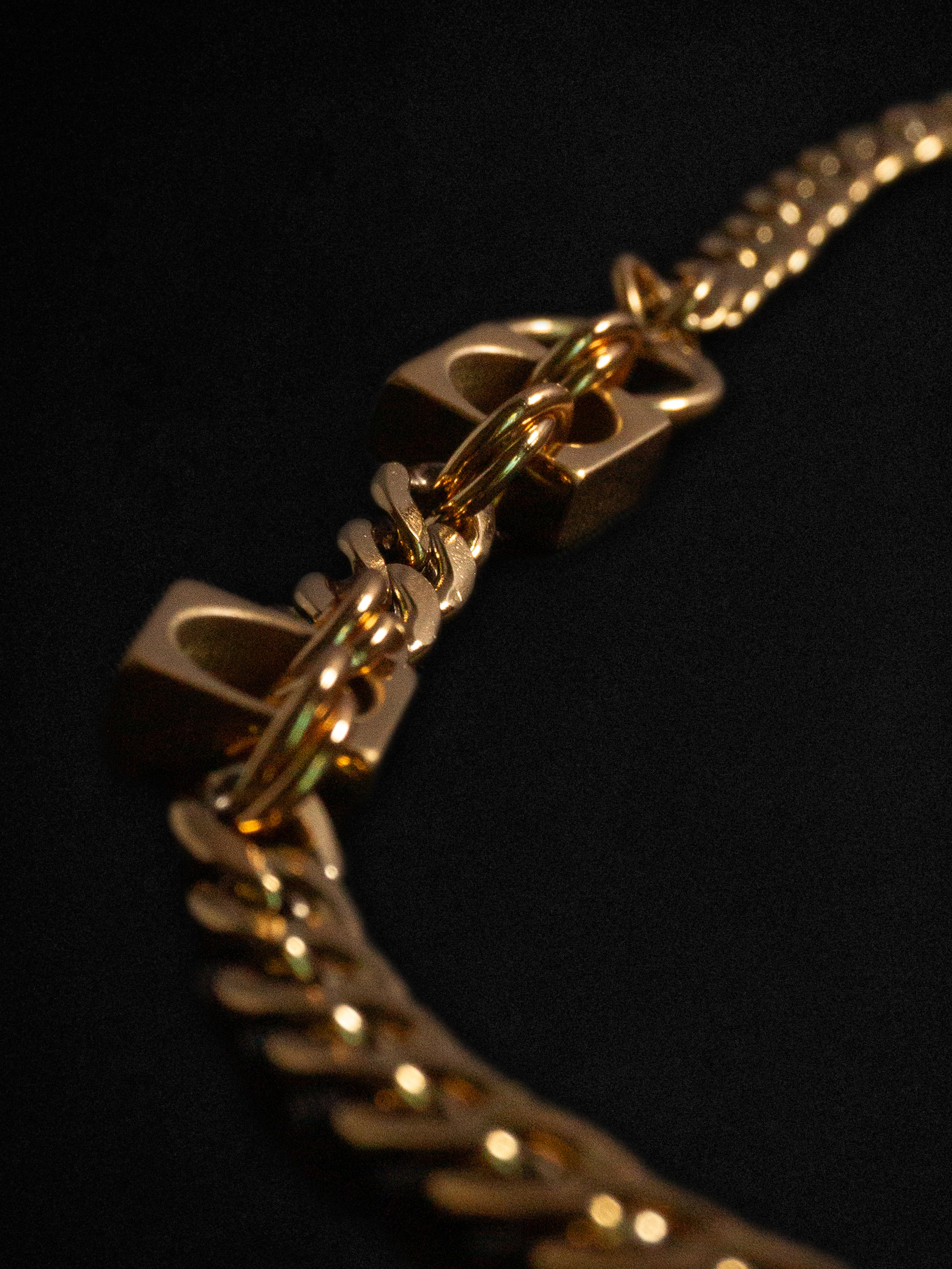 Close-up of a gold chain necklace on a black background