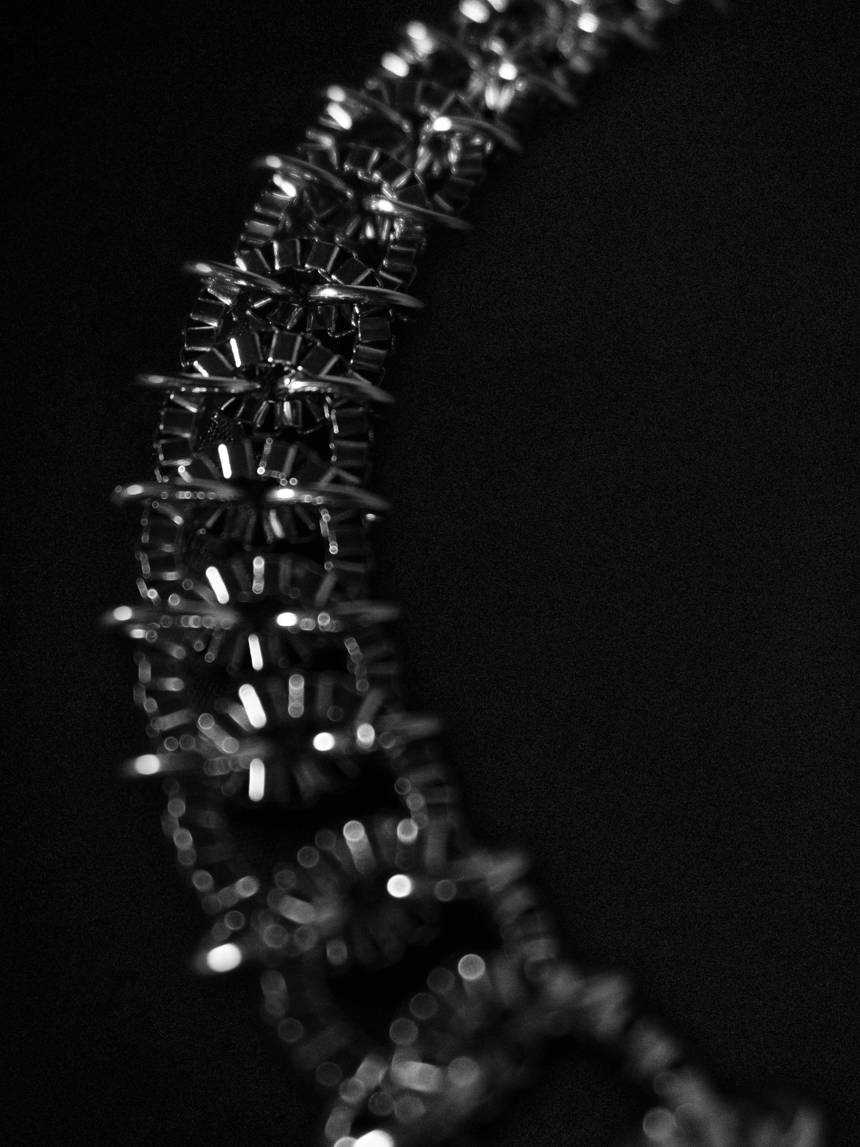 Close-up of a metallic silver chain on a black background