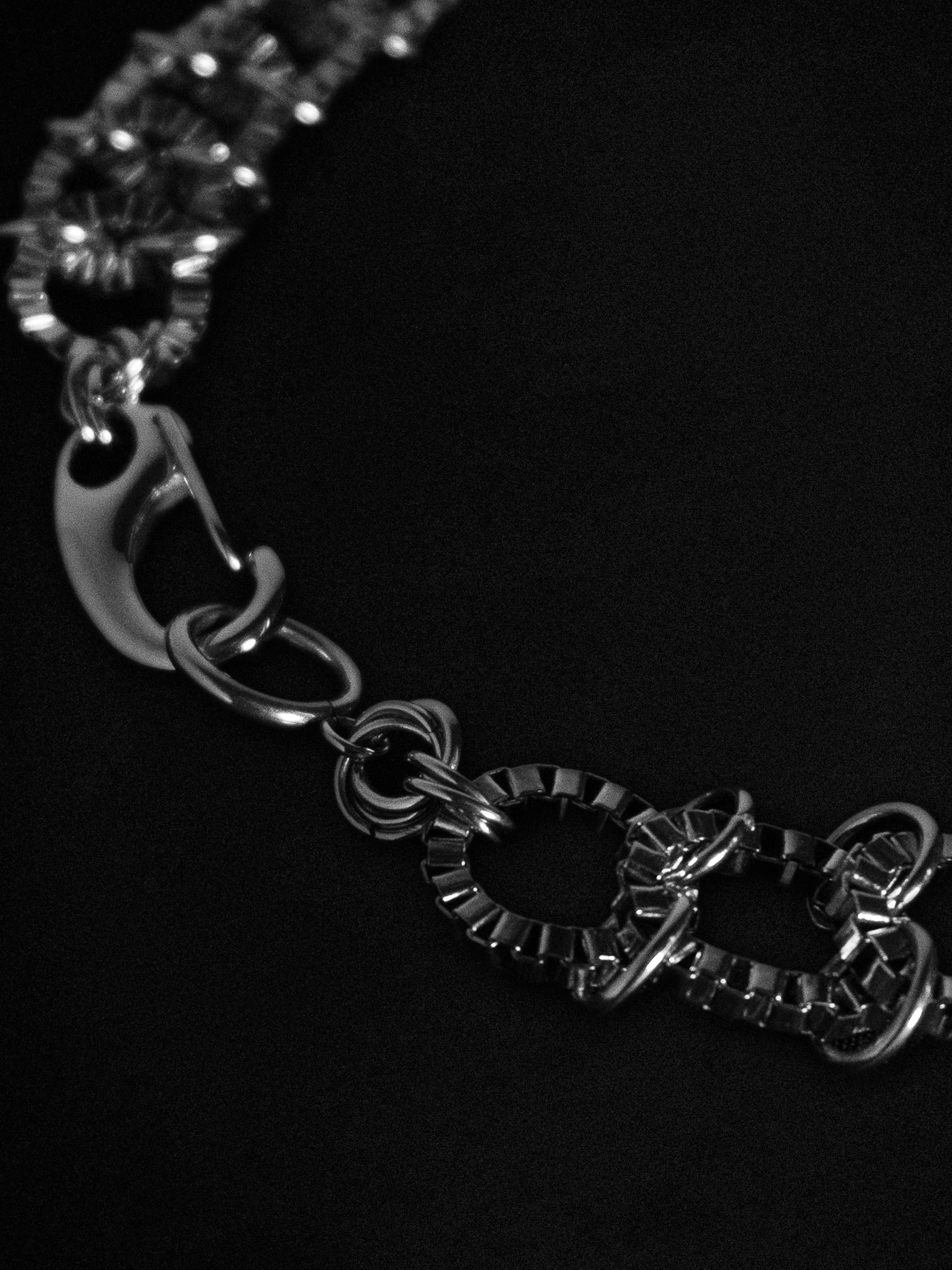 Close up of a silver necklace on a black background