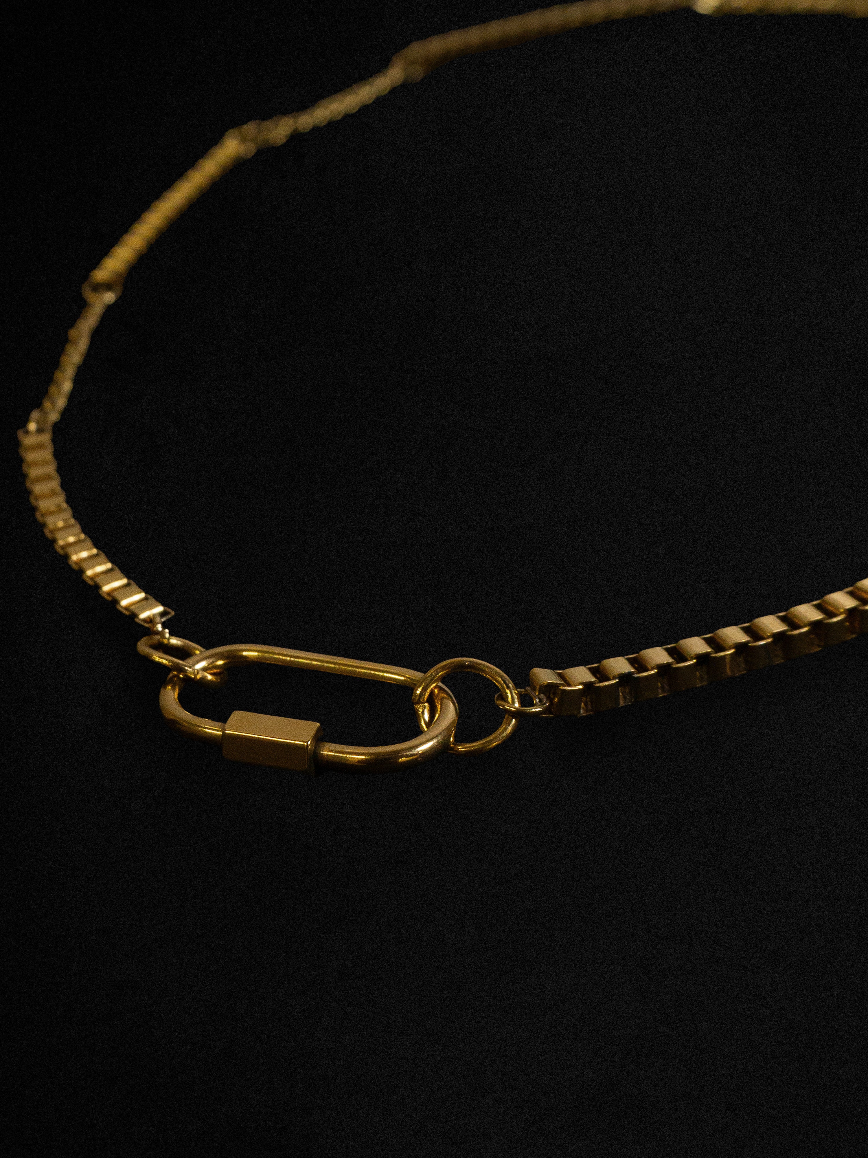 Gold chain necklace on a black background