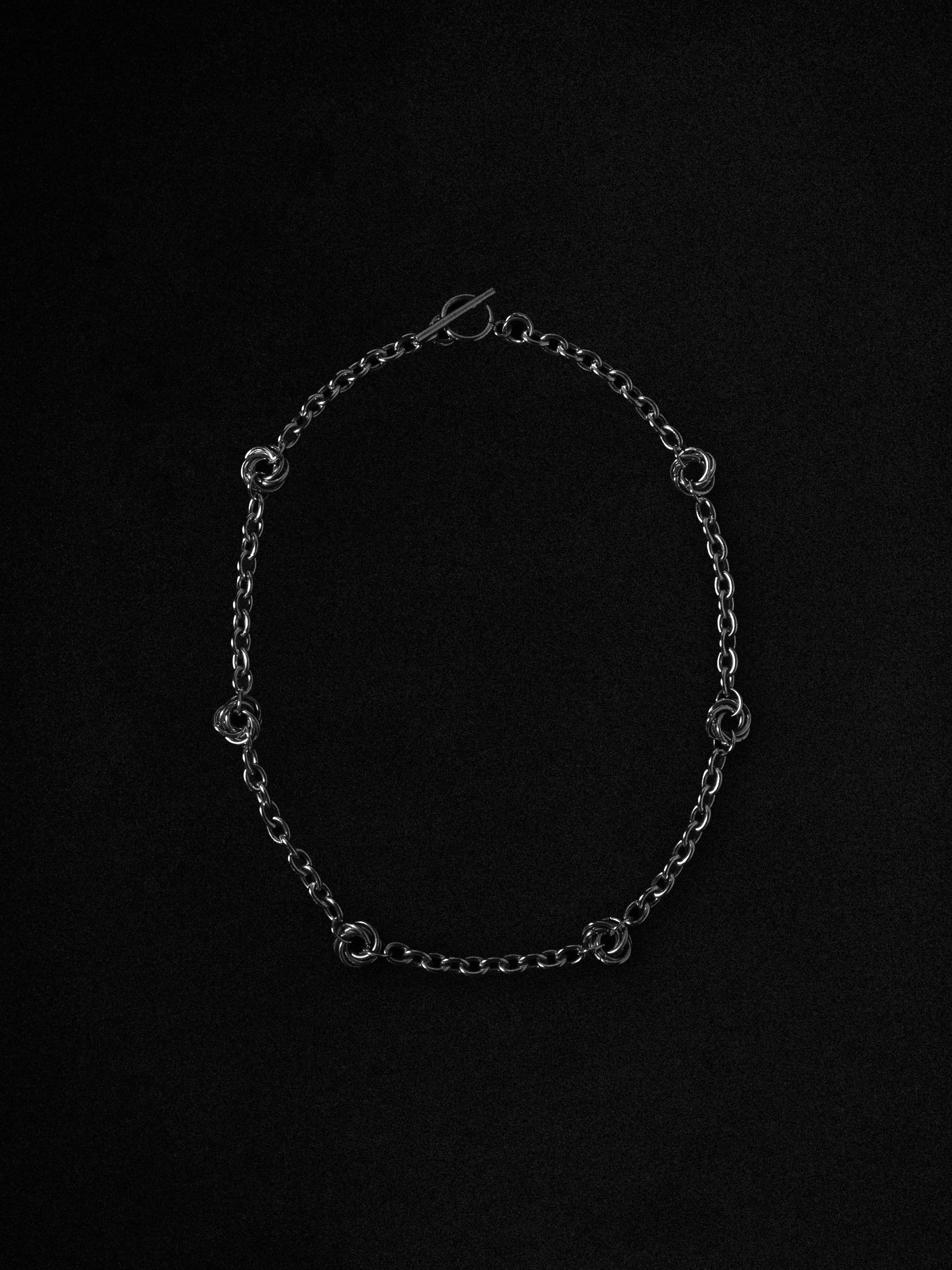 Silver chain necklace on a black background
