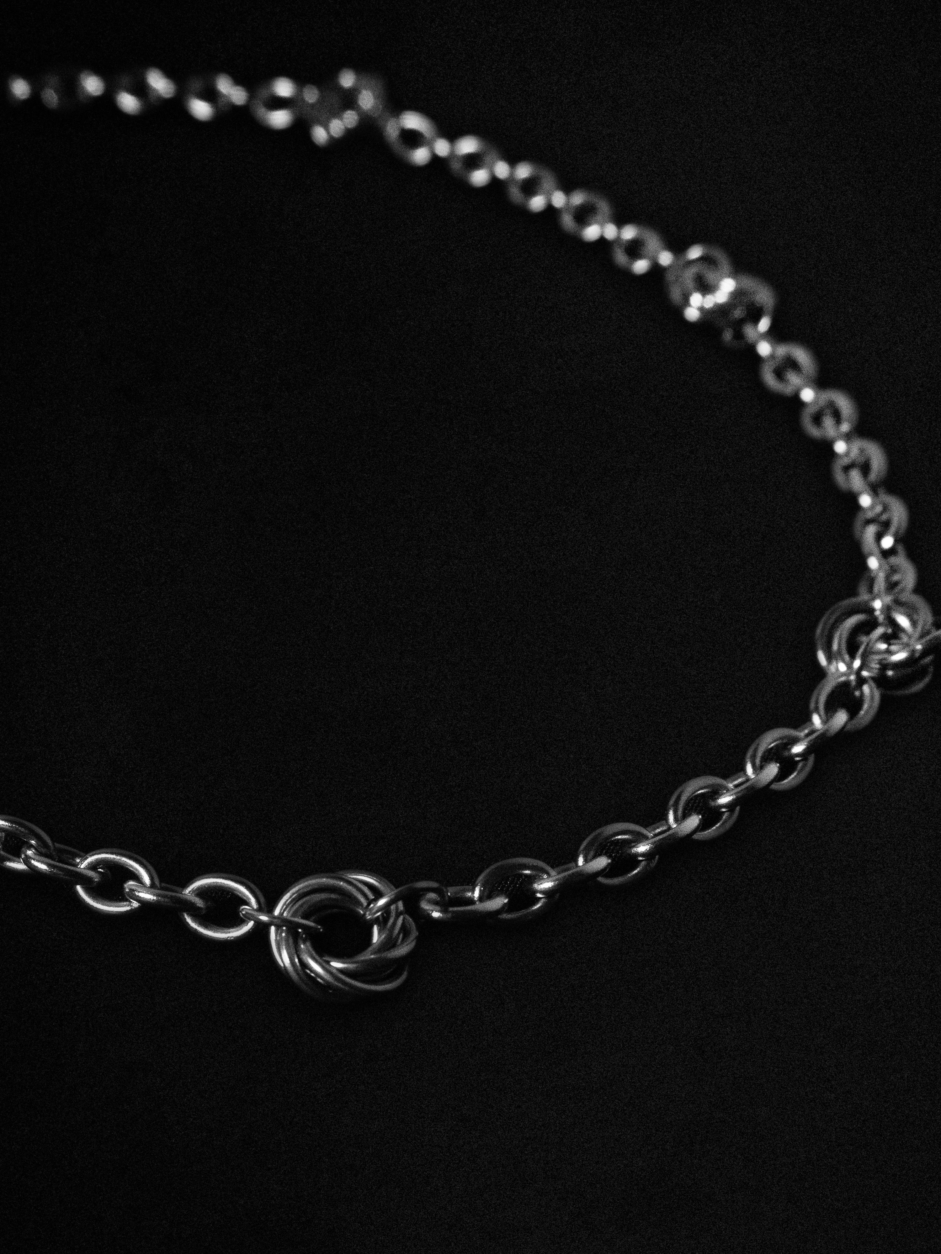 Silver chain necklace on a black background