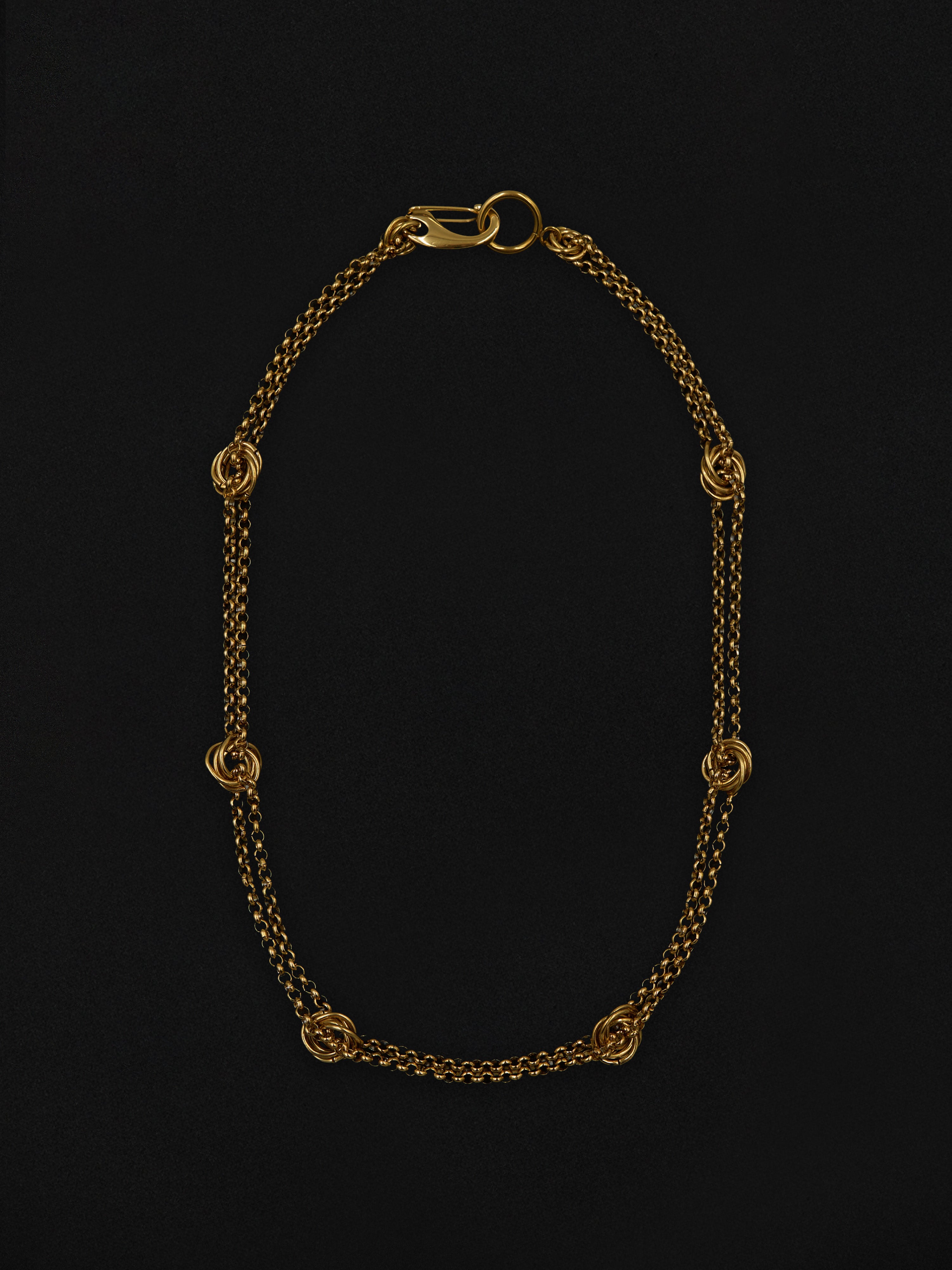 Gold chain necklace on a black background