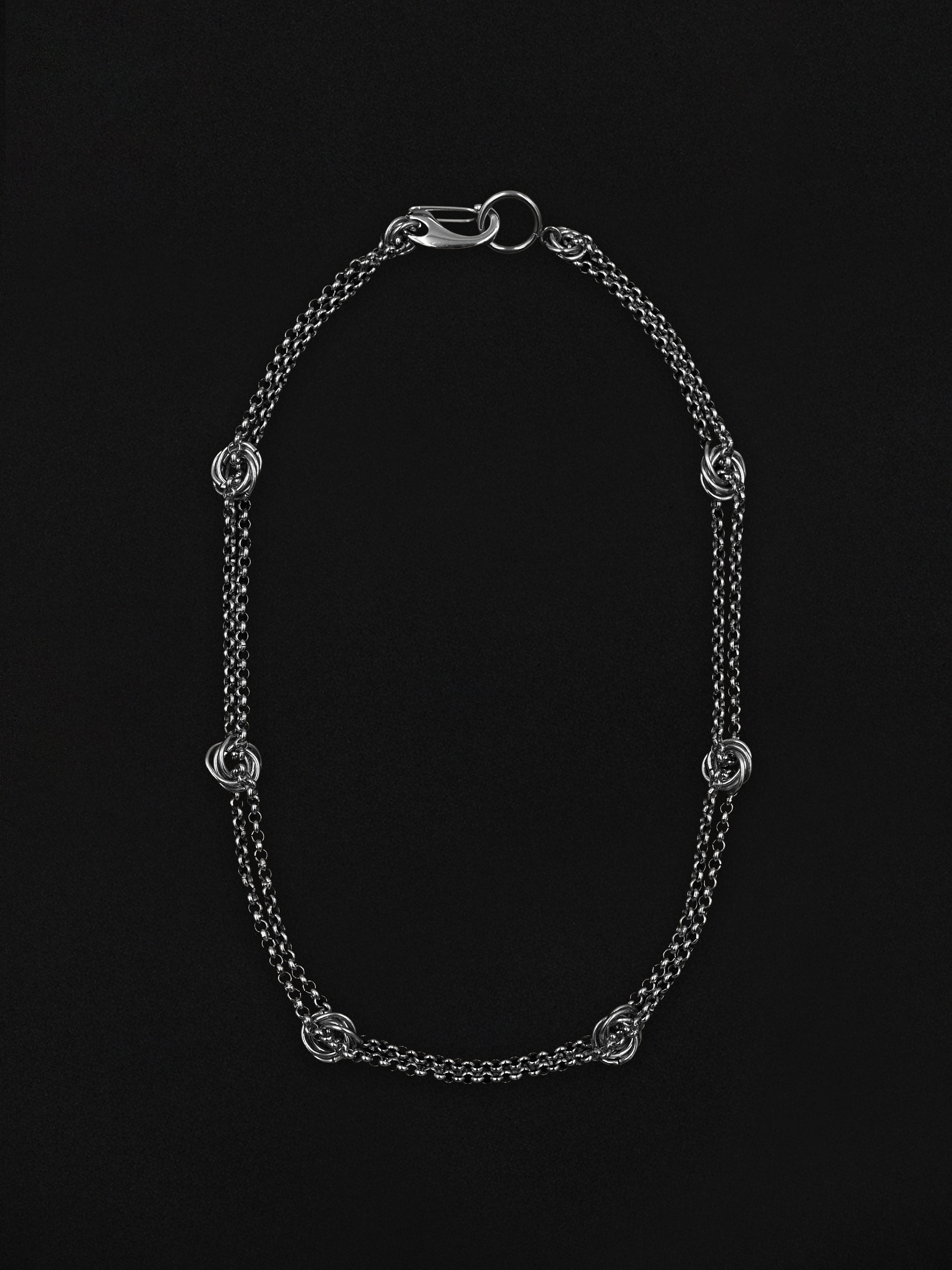 Silver chain necklace on a black background